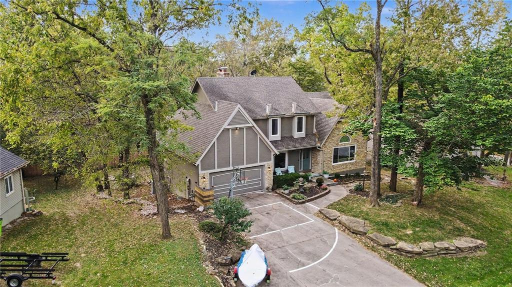 BEAUTIFULLY REMODELED HOME WITH MAIN-LEVEL PRIMARY SUITE & LAKE PRIVILEGES IN WEATHERBY LAKE! Welcome to the lifestyle you've been dreaming of! Nestled among mature trees in the highly desirable community of Weatherby Lake. This beautifully updated 5-bedroom, 4.1-bath home with a 3-car garage offers the perfect blend of modern luxury, timeless character, and resort-style lake living! Thoughtfully remodeled and updated throughout, this home impresses with rich hardwood floors, beautiful architectural details, and multiple inviting living spaces. The stunning kitchen features crisp white cabinetry, a contrasting blue center island, gorgeous countertops, designer tile backsplash, stainless steel appliances, and abundant storage. A dramatic floor-to-ceiling stone fireplace anchors the spacious living room, while the formal dining room showcases rich wood-paneled walls and elegant architectural details. Newer HVAC. The beautifully remodeled primary suite is a true retreat, featuring hardwood floors, custom accent wall, & a spa-inspired bathroom complete with dual vessel sinks, custom cabinetry, an oversized walk-in shower, and gorgeous designer tile finishes. With 5 bedrooms and multiple living areas, there's plenty of room to spread out! Enjoy a light-filled living space with custom built-ins, spacious secondary bedrooms (all with walk-in closets) and a finished lower level featuring a recreation room with brick fireplace and flexible space for a home gym, office, or hobbies. Step outside and enjoy the peaceful, tree-filled backyard, complete with a deck and fire pit—perfect for outdoor entertaining, relaxing evenings, or gathering around the fire. THE WEATHERBY LAKE LIFESTYLE IS THE TRUE BONUS! Enjoy lake privileges and an incredible array of recreational and social opportunities, including boating, sailing, fishing, a swim beach, clubhouse, tennis courts, basketball courts, & a vibrant community of social clubs, including yacht, garden, fishing, & book clubs.