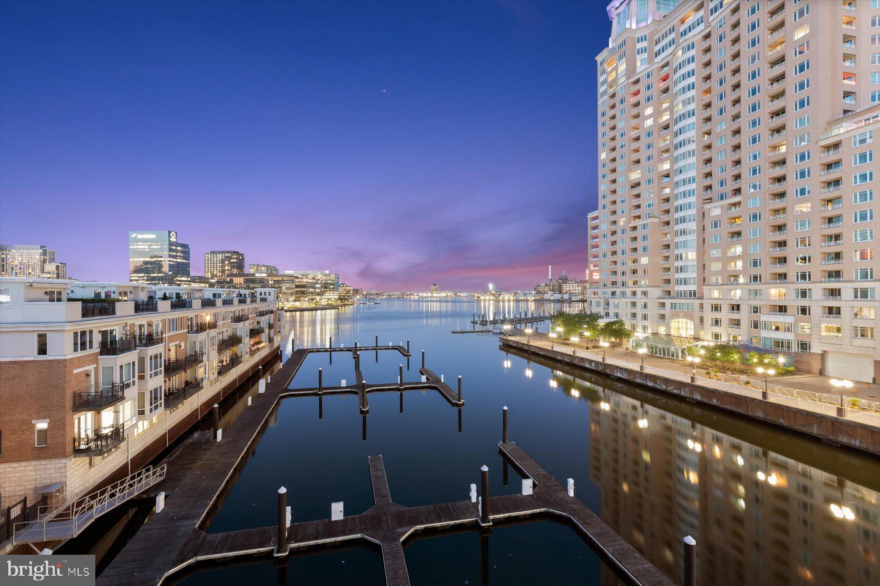 Pier Homes Living.  Experience The Difference.  Envision your new lifestyle within the distinguished The Pier Homes at Harborview.  Extremely rare opportunity to own one of only four end of pier located homes within the community.  This pristine condition, amenity rich, four bedroom corner residence with elevator features an impressive contemporary floor plan with 4,156 square feet of luxury living & panoramic direct waterfront views from all five levels.  **EXQUISITE FEATURES INCLUDE**  Formal dining room featuring custom built-in cabinetry and two wine coolers, three separate wet bars with beverage coolers, gourmet kitchen with granite counter tops, pantry, built-in refrigerator, Viking gas stove and double ovens, stainless steel microwave and dishwasher, master bedroom suite with ensuite bathroom featuring custom tiled oversized walk-in shower with overhead and side sprays, double vanities and multiple toilets, full-home Sonos audio system including outdoor balcony and roof level speakers, multiple built-in rolling shelving units surrounding the fourth level fireplace, custom window and blind treatments, dual-zone HVAC, two hot water heaters, three gas fireplaces, hand scraped hardwood flooring, dedicated first level laundry room with washer, dryer and drying rack, and security system.  Parking for four vehicles is provided for within the attached two car garage and two car brick paved parking pad.  The wrap-around exterior balconies on the second and third level of the home combined with the spacious rooftop terrace featuring Duradek flooring, a commercial grade retractable awning, and natural gas outlet provide ample outdoor entertaining space and panoramic city skyline & water views.  Community amenities include a private guest parking garage, outdoor pool, private fitness center, welcome center with concierge services, private trash & snow removal, marina, Bellini’s dock bar, DiPasquale’s Italian deli & market, waterfront promenade walking/jogging/biking path and beautifully landscaped grounds.  A conveniently located water taxi can take you to explore any neighborhood in the city.  With countless shopping, dining and entertaining options just minutes away from this centrally located Inner Harbor property you can enjoy a lifestyle offered nowhere else in Baltimore.  Combined with gated access, 24/7 security and private on-demand security escorts this home provides one of the most luxurious & secure lifestyles offered in Baltimore.