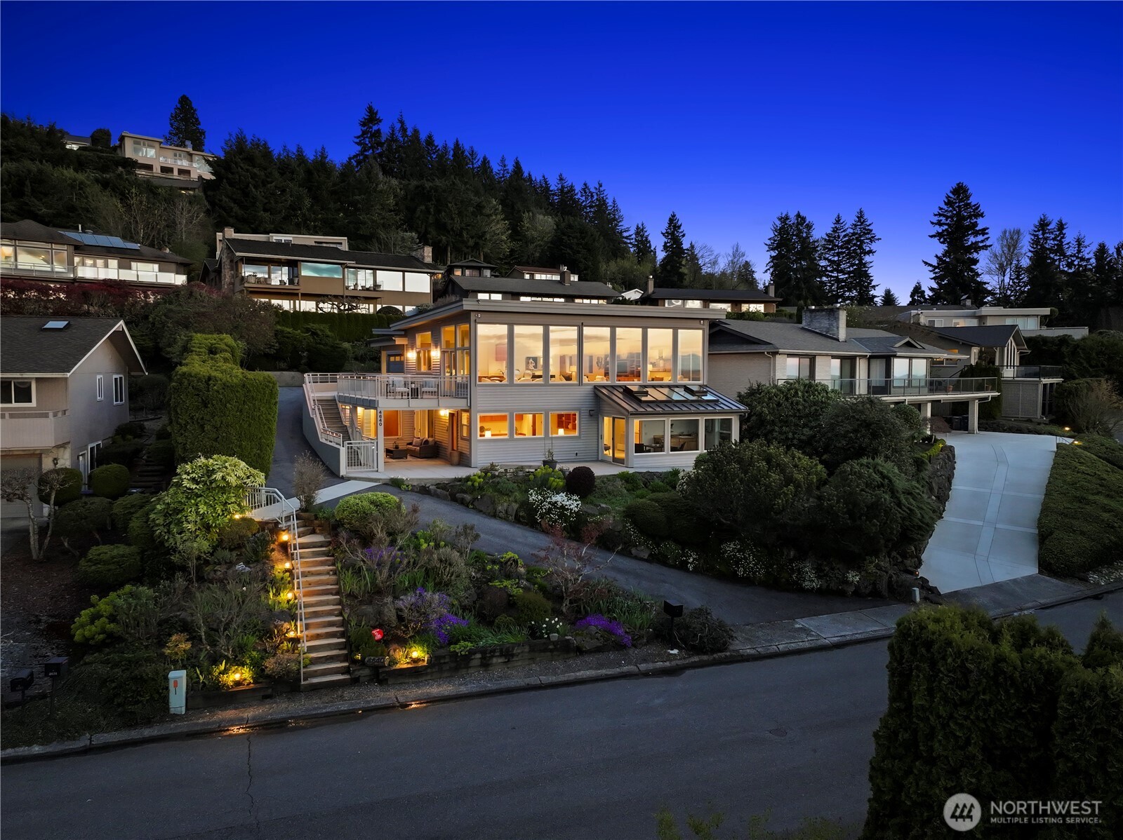 Welcome to this exceptional custom residence by premier builder Steve Kunkel, thoughtfully designed to capture breathtaking 190+ degree panoramic views. From the glittering skylines of Seattle & Bellevue to the serene beauty of Lake Washington, Puget Sound & majestic Cascade Mountains, this contemporary home offers a front-row seat to the Pacific Northwest’s finest scenery. Created for both luxurious everyday living & unforgettable entertaining, the home has graciously hosted gatherings of over 100 guests with ease. The expansive great room features soaring 12-foot ceilings & walls of windows that frame ever-changing city & water views. The spacious chef’s kitchen is equipped with stainless-steel appliances & 2 eating bars—perfect for casual meals or lively gatherings—while offering ample space for the busiest cook. 3 bedrooms and 3.5 baths, highlighted by a serene primary suite with a spa-inspired five-piece bath. A temperature-controlled wine room ensures your collection is perfectly preserved. Multiple outdoor living spaces invite you to relax and take in the surroundings, including a generous view deck off the dining room, a covered patio off the lower-level guest room, and a tranquil sunroom adjoining the primary suite. A private elevator enhances convenience and accessibility, offering ease of living today & flexibility for aging in place. Beautifully curated, low-maintenance gardens offer vibrant year-around color. A truly exceptional home for the discerning buyer.
