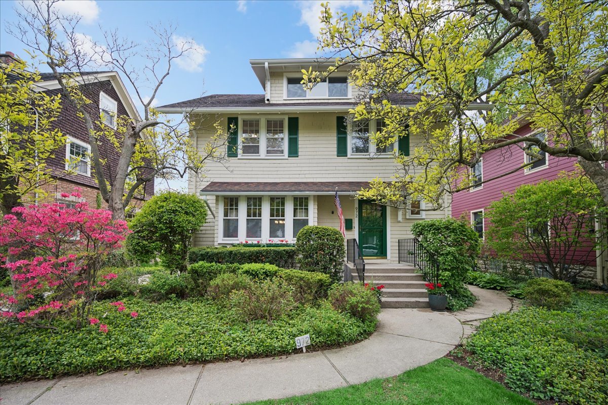 Bright, spacious, and beautifully maintained, this charming home offers timeless character, gracious proportions, and an exceptional in-town location on a lush, deep lot with a gorgeous patio with thoughtfully designed seating wall - perfect for entertaining and outdoor enjoyment. High ceilings, classic architectural details, and abundant natural light create a warm and inviting atmosphere throughout.  The gracious living room features handsome built-ins and a lovely bay window overlooking the picturesque front yard and sought-after neighborhood, just moments from town, train, parks, and K-8 schools. The formal dining room is beautifully proportioned for both everyday living and special gatherings, while the inviting den/family room opens seamlessly to the sunny south-facing backyard.  The bright eat-in kitchen offers abundant cabinetry and prep space, generous table space, and delightful views of the beautifully landscaped yard. Upstairs, the spacious primary suite includes a large bedroom, private office or sitting room with beautiful views of the lush south yard, dressing area and an en suite bath. The third-floor retreat provides wonderful flexibility as a large 4th bedroom, playroom, office, or yoga studio.  The finished lower level includes a recreation/playroom, additional bedroom/office, full bath, and extensive storage. Freshly decorated and meticulously cared for throughout, this is an absolutely charming home in a vibrant neighborhood close to town, train, golf course, playfields, tennis center, and schools. A truly special offering.