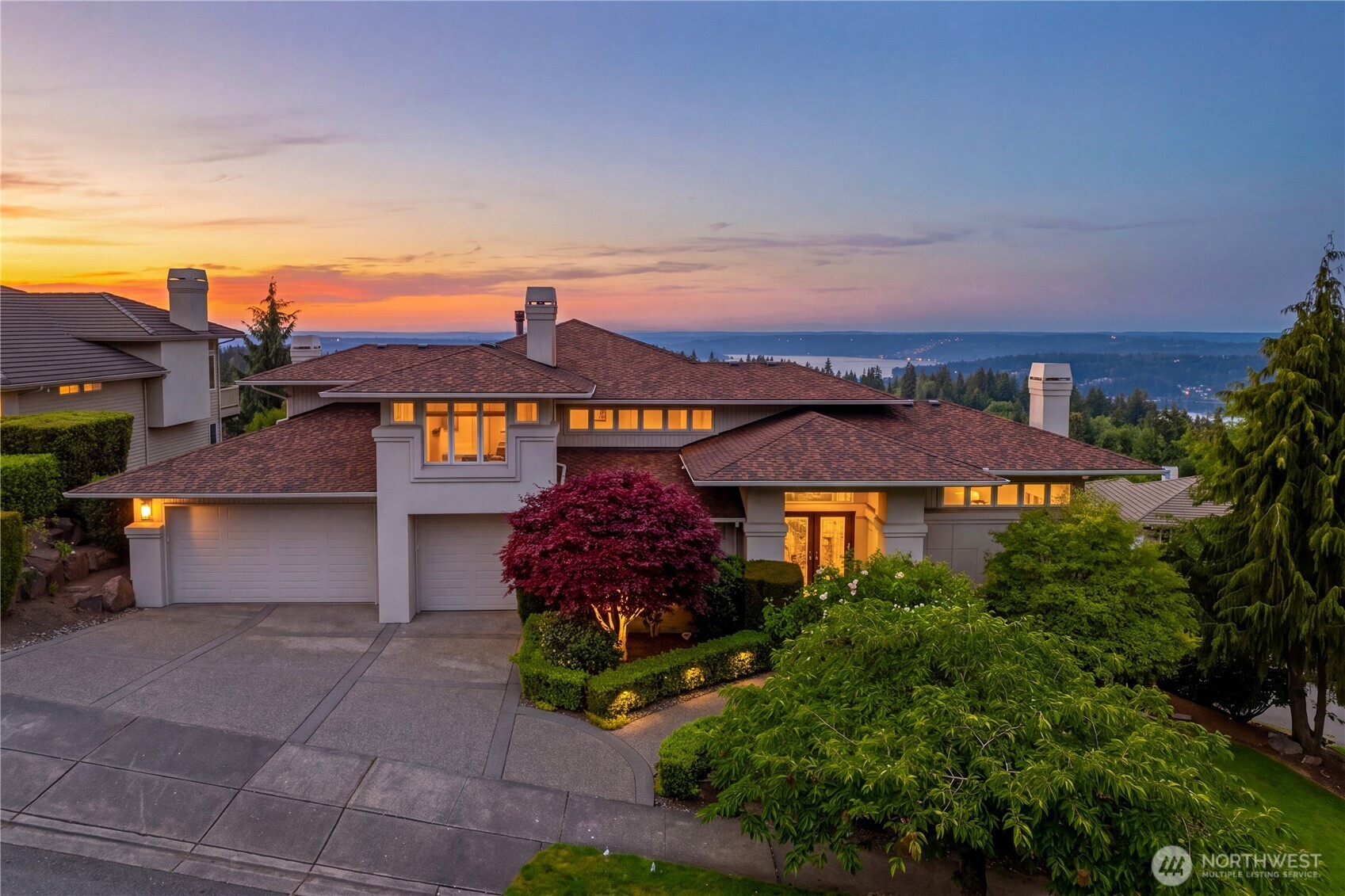Exceptional lake and mountain views surround this beautifully designed luxury home. A dramatic entry showcases a floating staircase, vaulted ceilings, and abundant natural light throughout. Recent updates include a remodeled primary bathroom featuring a freestanding soaking tub, designer shower, and premium tile finishes; a refreshed family room with an elegant new tile surround and fireplace enhancements; interior repainting; a circulating hot water pump for improved efficiency; newer marble countertops in the kitchen and all bathrooms; newer hardwood flooring in the living room and family room; a newer range hood; and a 2022 roof replacement with a lifetime warranty, providing exceptional value and peace of mind for luxurious living.  The luxurious primary suite captures breathtaking lake and mountain views and features a fireplace and oversized walk-in closet. An adjacent flex space off the primary suite offers versatility for a private office, nursery, reading lounge, or playroom to accommodate a variety of lifestyles. The thoughtfully designed multi-generational layout separates the primary suite from the guest and secondary bedrooms on different levels, providing enhanced privacy and flexibility.  Downstairs, the second ensuite bedroom and two additional bedrooms are connected by a spacious flex area ideal for a home gym, media room, second office, or creative space. Just minutes from I-90, the home offers convenient access throughout the region.