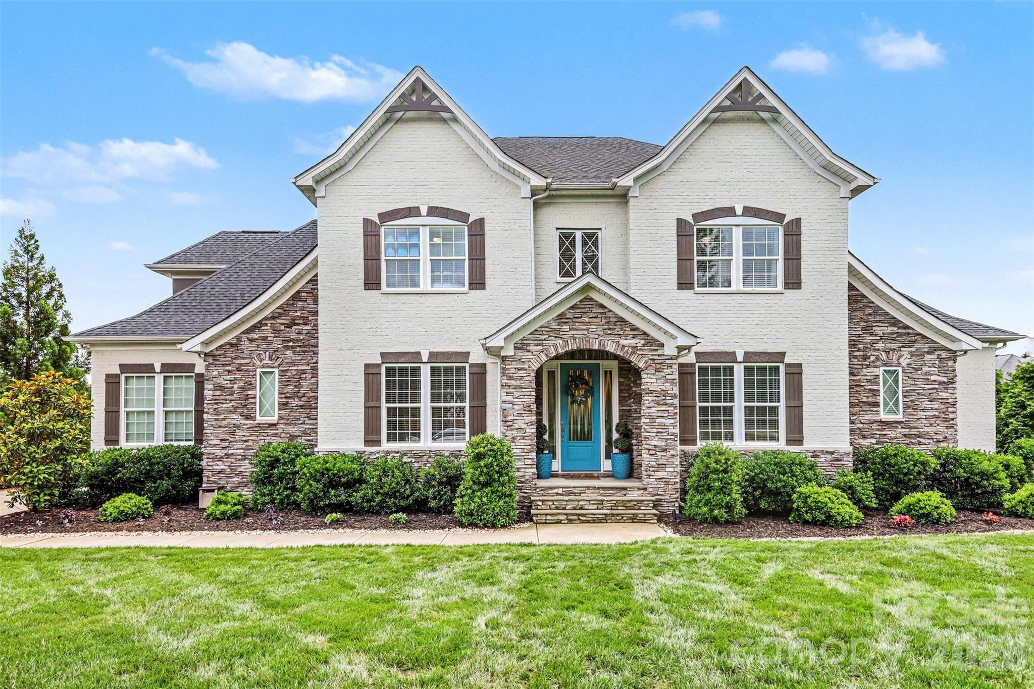 Located in the gated community of Quintessa, this full brick and stone 5BR/4.5BA home sits on nearly an acre and offers extensive upgrades throughout. Built in 2021, the home features a gourmet kitchen with oversized island, upgraded granite, gas cooktop, butler’s pantry, and a main-level primary suite with custom closet, oversized shower, and freestanding tub. Hardwood floors run throughout the main living areas, stairs, and upper hall. Recent additions include a sunroom/dining room with oversized Pella windows, custom hardscaping and lighting, fire pit, pickleball/play court, irrigation system, and expanded outdoor living space. The conditioned 3-car garage features polyaspartic flooring, plus a separate 4th garage with EV/Tesla charging and 220V setup for a car lift. Quintessa amenities include a pool, tennis courts, clubhouse, sidewalks, and gated entry.