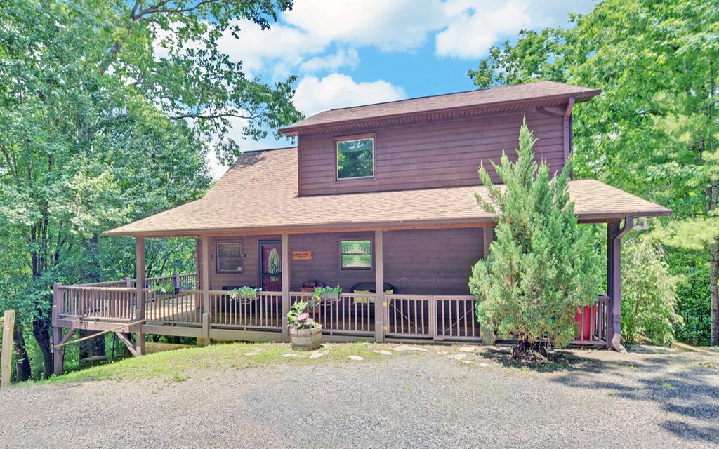 Escape the chaos and come home to this 2-bed, 3-bath mountain chalet, where warm wood interiors, soaring ceilings, and wraparound decks create the ideal blend of comfort and escape. The vaulted great room anchors the home with natural light and a striking fireplace, while the kitchen's breakfast bar invites easy mornings and relaxed entertaining. Two main-level bedrooms open directly onto the expansive deck, offering instant access to the outdoors. Upstairs, the loft suite with full bath offers a spacious retreat that could easily serve as the primary bedroom or a welcoming guest haven. A fully finished basement adds valuable flex space for hobbies, hosting, or downtime. Set on .86 acres with a wood-sided exterior, outbuilding storage, and a deck that wraps around three sides, this property is designed for real mountain living. Just minutes from Murphy's shops, restaurants, rivers, trails, and more, it's the kind of home that solves the question of where to recharge, without compromise.