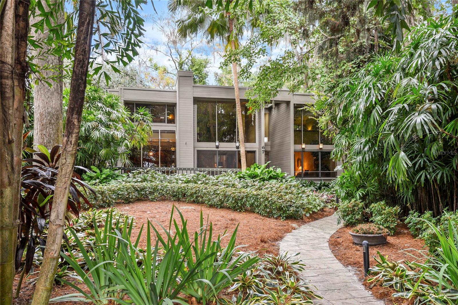 Welcome to 67 Cypress Lane, a stunning single-owner custom residence nestled among majestic Cypress and Oak trees across from Lake Maitland in one of the area's most coveted neighborhoods. This architectural gem, expertly crafted from Western Red Cedar, offers two stories of thoughtfully designed living space with 4 bedrooms and 3 full baths.Step inside to discover hardwood floors flowing throughout the first level, leading to a dramatic sunken living room and formal dining room perfect for entertaining. The heart of the home is the spectacular family room featuring soaring 17-foot ceilings, a wood-burning fireplace, and expansive windows that bathe the space in natural light. The well-appointed kitchen boasts granite countertops, a charming breakfast nook, and glass sliders opening to a covered side porch—ideal for morning coffee or evening relaxation.The main level also includes a convenient guest bedroom and full bath, separate living and dining rooms, plus an attached 2-car garage. Upstairs, retreat to the loft-style primary suite with private en suite bath, two additional guest bedrooms, a hall bath, and laundry facilities for ultimate convenience.Outdoor living shines here with a front deck off the family room and multiple porch spaces. The quiet, dead-end street ensures peace and privacy. For just $100/year, the optional HOA provides deeded park access to beautiful Lake Maitland directly across the street—feel the refreshing lake breeze from your front door!Just minutes from the Winter Park Racquet Club and all that downtown Winter Park and Maitland have to offer. Zoned for award-winning Dommerich Elementary, Maitland Middle, and Winter Park High School. Complete with Terminix termite bond for peace of mind. This tranquil neighborhood retreat offers a rare combination of custom quality, natural beauty, and an unbeatable location. Don't miss this exceptional opportunity!