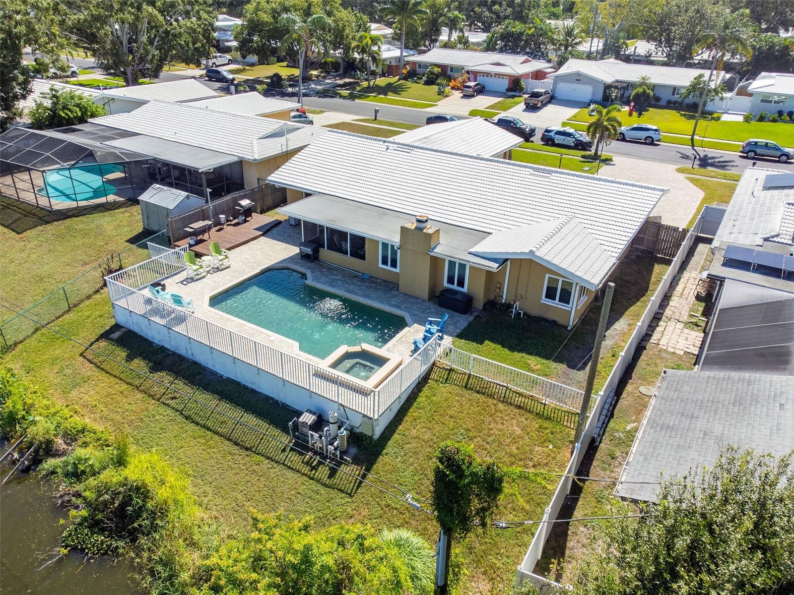 Motivated seller! Welcome home to Imperial Park, one of Clearwater’s most established and family-friendly neighborhoods! This stunning 4-bedroom, 3-bath pool home offers over 2,697 sq. ft. of living space perfect for multi-generational living and showcases numerous upgrades, including a beautifully updated open-concept kitchen with marble countertops and a convenient bar area, formal living and dining rooms, and a cozy family room with fireplace overlooking the sparkling pool. The extra-large primary suite features a walk-in closet, while hardwood floors in the bedrooms and tile throughout add timeless appeal. Enjoy year-round Florida living in the spacious Florida room or outdoors on the paver pool deck, perfect for entertaining while taking in serene pond views. Additional highlights include a large inside utility room, two-car garage, and recent updates such as a tile roof, AC, insulation, saltwater pool conversion with upgraded equipment, and paver driveway. Ideally located near top-rated schools, shopping, restaurants, parks, award-winning beaches, airports, and theme parks. Schedule your private showing today and experience the best of Clearwater living.