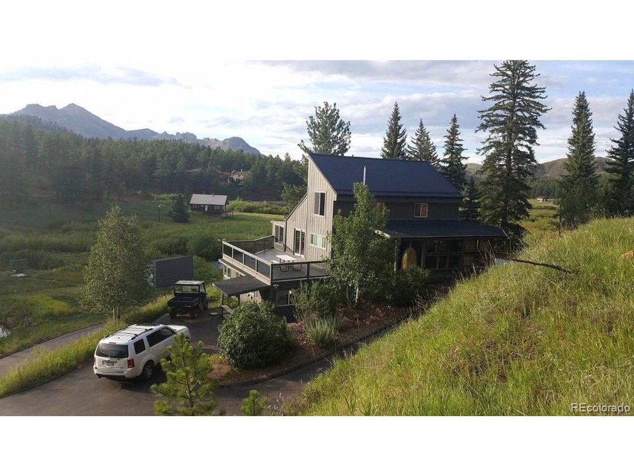 Perched above a peaceful meadow with a flowing creek, this 2.507-acre property (spanning three lots) offers a true Colorado mountain lifestyle. Wildlife frequents the property, and mornings begin with birdsong in a serene, private setting. Enjoy expansive outdoor living with a three-sided deck (covering 2 sides) featuring stunning stained glass accents, a fenced yard ideal for pets or gardening, and a 10x20 storage shed. Inside, you're welcomed by a main-level bedroom and bathroom, followed by an open-concept living and dining area with soaring vaulted, beamed ceilings. The kitchen is surrounded by walls of windows, creating a treehouse-like feel, and features endless counter space, recently updated stainless steel appliances and incredible views of the creek and meadow. A spacious secondary bathroom with tile accents completes the main level. Upstairs, a spiral staircase leads to a loft with two flexible living spaces, separated by a large closet and built-in storage. The lower level offers substantial bonus square footage ready for your vision-perfect for a home office, workshop, gym, classroom, or additional living space-plus abundant storage throughout the home. Serviced by a private well (not part of the Westcreek Lakes water system). Optional fishing club membership available. Located near 250,000+ acres of Pike National Forest for endless outdoor recreation. A rare opportunity to own an idyllic Colorado retreat with space, privacy, and endless potential.