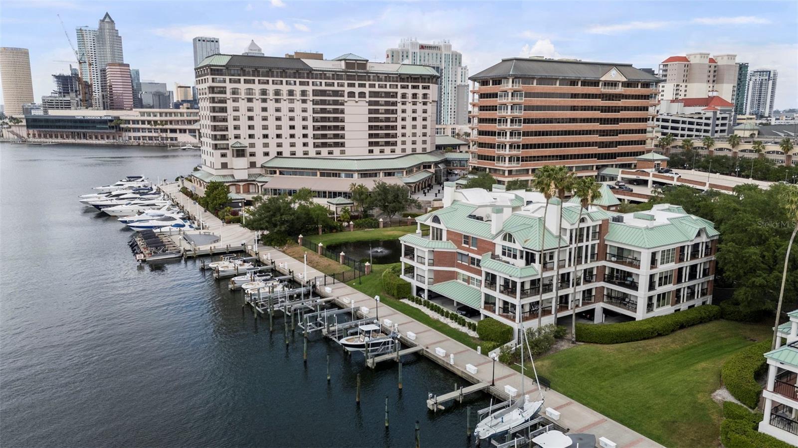 Under contract-accepting backup offers. Welcome to elevated waterfront living in one of Tampa’s most exclusive enclaves. This stunning 2-bedroom, 2.5-bath condo at 707 Seddon Cove Way is nestled within the prestigious 24-hour guard-gated community of Harbour Island, offering both privacy and convenience in the heart of the city.Step inside and immediately notice the warmth of rich parquet wood flooring complemented by elegant marble accents, creating a sophisticated yet inviting atmosphere. The spacious living area is anchored by a charming wood-burning fireplace—perfect for cozy evenings—and flows seamlessly out to the largest covered lanai in the building. From here, enjoy breathtaking water views, including a serene pond to the right, making it an ideal space for relaxing or entertaining.The kitchen comes fully equipped with all appliances, including an in-unit washer and dryer and a brand-new wine refrigerator—perfect for hosting or unwinding after a long day. Fresh paint throughout and a newly updated bathroom vanity add a crisp, modern touch.This well-maintained community has recently undergone significant upgrades, including new roofs and elevators, ensuring peace of mind for years to come. Residents also enjoy access to a sparkling community pool and beautifully landscaped surroundings.Location is everything, and this condo delivers. Just steps away, you’ll find yourself within walking distance of Tampa’s most vibrant destinations, including Water Street, the Tampa Convention Center, the Riverwalk, and Davis Islands. Whether you’re seeking fine dining, entertainment, or outdoor recreation, it’s all right at your doorstep.This is more than a home—it’s a lifestyle. Don’t miss your opportunity to own a piece of paradise in Harbor Island.