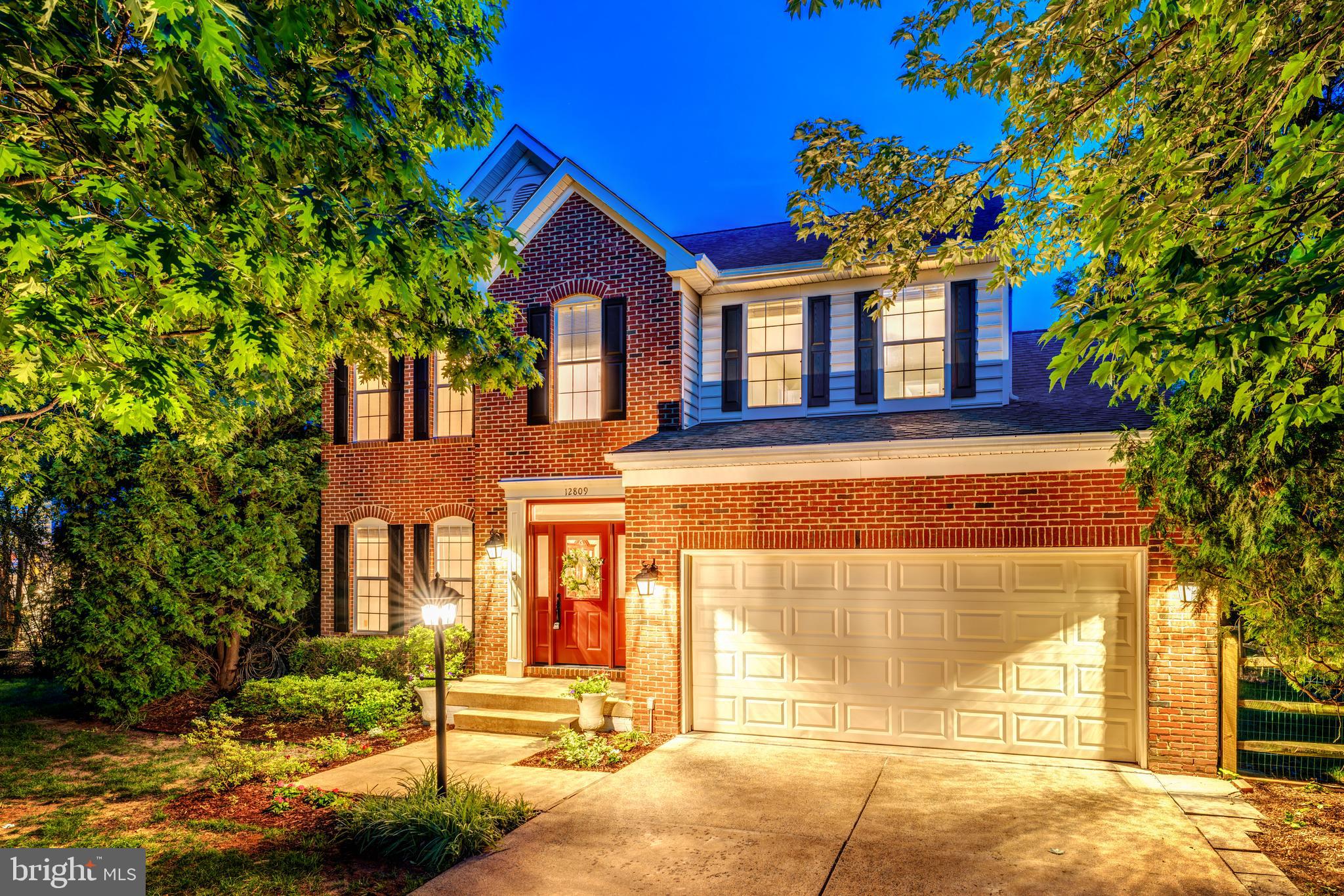 Located on a quiet street in Polo Fields and within walking distance of the Herndon Metro, 12809 Tournament Drive offers thoughtfully updated living space, a large flat fenced yard, and a location that keeps Dulles Airport, Reston Town Center, Old Town Herndon, the Dulles Toll Road, and Fairfax County Parkway all close at hand. A brick front exterior, manicured landscaping, two-car garage, and two-story foyer create a welcoming first impression. Hardwood flooring extends through the foyer, hallways, formal dining room, and kitchen, while 9-foot ceilings add to the sense of space throughout the main level. The remodeled kitchen features 42-inch white cabinetry, premium granite countertops, a generous center island, stainless steel appliances, tile backsplash, recessed lighting, and a large breakfast area surrounded by windows that bring in exceptional natural light. The kitchen flows directly into the family room and opens through a sliding glass door to an oversized deck with multiple seating areas overlooking mature trees, open space, and a beautifully maintained rear yard. Upstairs, the spacious primary suite includes a walk-in closet with a custom Elfa organization system and a newly renovated bath featuring a white dual-sink vanity with abundant storage, quartz countertops, a freestanding soaking tub, seamless glass no-curb shower, contemporary tile selections, and a private water closet. Three additional generously sized bedrooms share an updated bath with Carrara tile, quartz-topped vanity, and barn-door style glass shower enclosure, while two of the bedrooms also include walk-in closets. The fully finished walk-up lower level provides remarkable flexibility with a county-permitted full kitchen featuring 42-inch cabinetry, premium granite countertops, stainless steel appliances, tile backsplash, and a separate buffet and bar area with granite surfaces and built-in beverage cooler. Additional lower-level spaces include a large recreation room, exercise room with water hookup, private den or office with French glass doors and recessed lighting, and an oversized laundry room with white shaker cabinetry, granite countertops, abundant storage, and space for hobbies, crafts, or household organization. Recessed lighting throughout the lower level, tile flooring, a walk-up exit to the backyard, and the combination of privacy, open space, and extensive indoor living areas make this home equally suited for everyday living, entertaining, multigenerational needs, or extended guest stays.