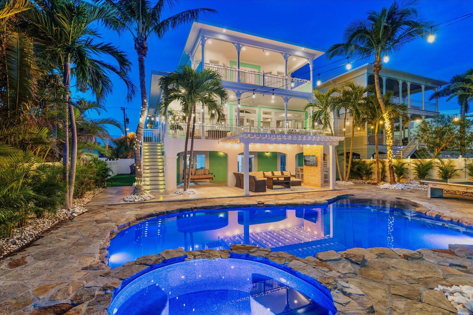 SURROUND YOURSELF IN PARADISE AT THIS ONE-OF-A-KIND, KEY WEST STYLE WATERFRONT BEACH HOME! Enjoy breathtaking views of Boca Ciega Bay, deep-water unobstructed boating access to the Gulf of Mexico and short walks to the white sands of St. Pete Beach. Custom built in 2004 to a 14' elevation and with Superior Construction quality, this meticulously crafted home features 4 spacious en-suite bedrooms, 5 ½ bathrooms, an elevator, 4-car garage, an office and a gym/media space with over 3,800 SQFT of Coastal living. Add in the 1,200 SQFT of covered balconies/patio and you have more than 5,000 SQFT of covered living space to enjoy the true Florida lifestyle!

The home features a bright and airy open-concept layout with 10’ ceilings and expansive windows that bring the beauty of the outside in. Enjoy seamless access to the outdoors from the grand living areas, perfect for entertaining guests or simply relaxing with the family. The Custom kitchen was made for a chef! Complete with Solid Wood Cabinetry, Granite counter tops, built in refrigerator and oven/micro combo, glass cook top, center prep island and large high-top bar for guests. No details were left out of this home! Lots of custom finishes from the coffered 10’ ceilings, crown molding throughout, solid wood flooring, plantation shutters, gas fireplace and an elevator to all levels. All bedrooms are large En-suites for privacy too! The primary suite is a true retreat, offering sweeping water views, walk in closet, a luxurious en-suite bathroom, and a private terrace perfect for enjoying sunsets over the bay.

Outside is a true Resort Style waterfront paradise. The new Trek dock and 30,000-pound boat lift provides direct unobstructed access to the Gulf of Mexico making it a dream for boating enthusiasts. The expansive outdoor living areas include large balconies, a full outdoor kitchen, built-in fire pit, beautiful heated pool/spa, 750 sqft of turfed space and plenty of room for lounging, dining, and entertaining—all set against the stunning backdrop of the bay. 

This remarkable home offers the ultimate coastal lifestyle, blending modern luxury with the natural beauty of St. Pete Beach. With its prime location, you can take a short walk to the beach, restaurants, shops and entertainment. St Pete Beach is not only #1 because of our beaches, we’re so close to everything! Only a 15-minute drive to Downtown St. Pete for nightlife and dining and only 30 minutes to Tampa International Airport. This is your opportunity to own a piece of paradise. This is more than just a home—it's a lifestyle.