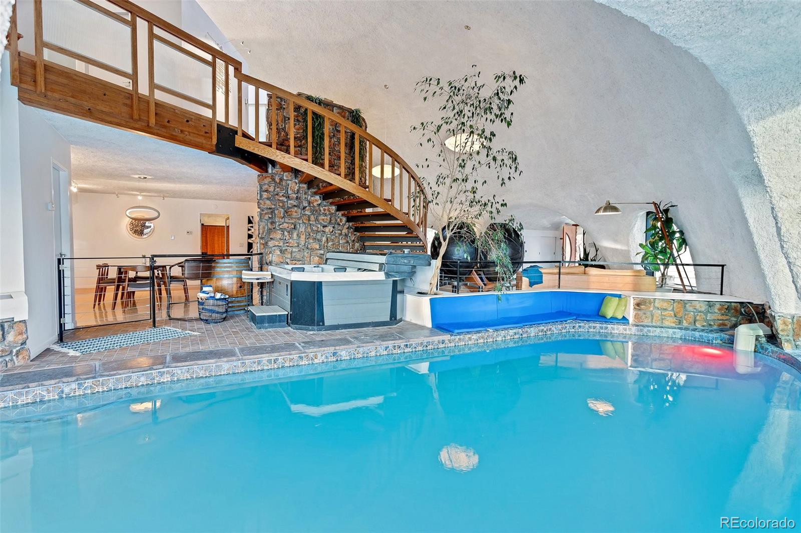 Welcome to one of the most distinctive homes in the Denver Metro area, a striking Monolithic Dome residence in the quiet, upscale neighborhood of Algonquin Acres. Originally designed by aeronautical engineer Chris Barnes, this one-of-a-kind property blends cutting-edge design with exceptional energy efficiency.Offering over 4,500 square feet of thoughtfully crafted living space, the home features four bedrooms, three updated bathrooms, and a luxurious main-level primary suite. Natural light floods the open layout, enhanced by newly installed triple-pane windows and sliding glass doors that lead to an indoor heated saltwater pool and hot tub, complete with waterfalls and seamless indoor-outdoor access. Heated terrazzo tile floors span the main level, adding warmth and style to the modern finishes throughout.Extensive updates, totaling over $600,000, include a full primary bathroom remodel, heated floors, upgraded fireplace, new septic and water systems, smart lighting, EV charger, three mini-split air conditioners, and a complete exterior overhaul with new insulation, waterproofing, stucco, and fresh paint. Recent owner improvements add even more value, with new hardwood flooring upstairs, upgraded pool equipment, a new deck and gazebo, resurfaced driveway, privacy fencing, a generator pad, and a high-powered dehumidification system for year-round comfort.Set on nearly an acre, the home offers proximity to Valley Country Club, Cherry Creek State Park, the Denver Tech Center, and top-rated Cherry Creek schools.Currently operating as a fully licensed and furnished short-term rental (Estimated $170k + in yearly revenue), this property presents an exceptional opportunity, whether you're seeking an unforgettable home or a high-performing investment. Rarely does a property this special become available.