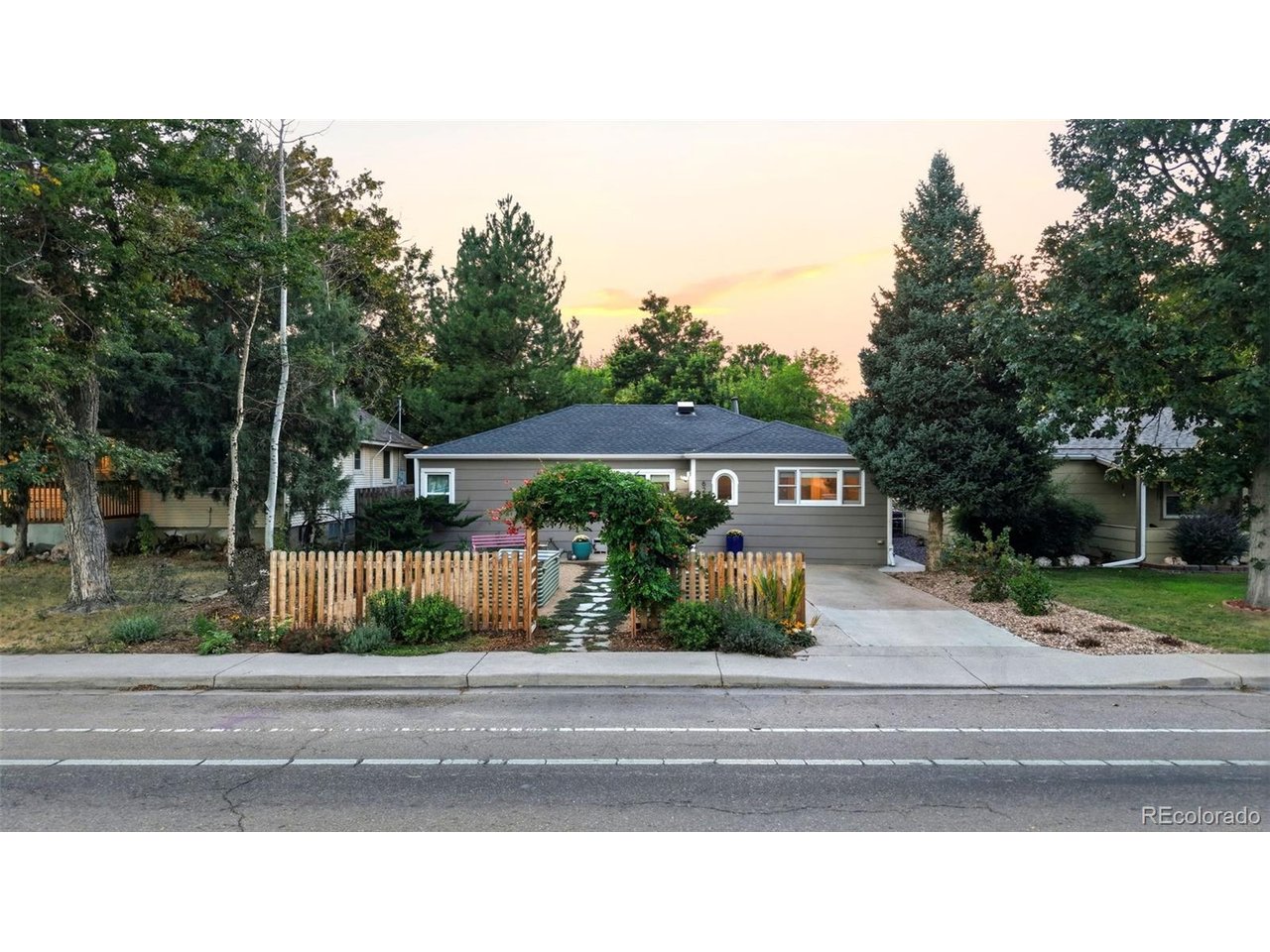 Discover this beautifully renovated 1940s bungalow on a double lot, with a gorgeous turn-key ADU complete with kitchen, washer/dryer, and full bathroom. In the main house, you'll see original hardwood floors, bright light from the picture window, and a peek at the expansive backyard through French doors. The primary bedroom and large windows, a custom closet, and an ensuite with a tiled shower, marble countertops, and skylight. Two more bedrooms each have a vintage built-in closet. The guest bath got a striking update in 2025 - bold marble tiles, heater floors, in midcentury style. The kitchen, updated in 2021 is just off the dining room and includes a Miele dishwasher and disposal (both 2026,) and gas range. The custom backlit dining room built-in (with a wine fridge, of course) is perfect for entertaining. Guests will grab a drink and be drawn to the patio and backyard - a sprawling lawn, mature trees and a professionally landscaped pollinator garden.  Follow the path to the (2024) studio apartment ADU. Guests have their own bathroom (with heated floors,) full-size laundry, and full kitchenette. All in a bright, bold style that is one-of-a-kind. Connected to the ADU there's a 1-car garage with EV charging, run by solar panels that come free and clear! The main house roof was replaced in 2021, new hot water heater, and a whole-house humidifier. Outside, you'll find mature grape vines along the back fence, a flagstone patio, and garden beds out front ready to plant, surrounded by a dreamy cottage garden. 10-minute walk to downtown Longmont. Upgrades and cool features include: custom closet shelving in primary, custom spice rack, salvage-wood library shelving, updated insulation and windows & treatments, tankless water heater, radon mitigation, concrete path around side of house, Nest thermostat, security cameras, stabilized floors (smart jacks plus new main beam,) all from caring owners who put thought into every detail! Trash day is Tuesday - Let's GO!