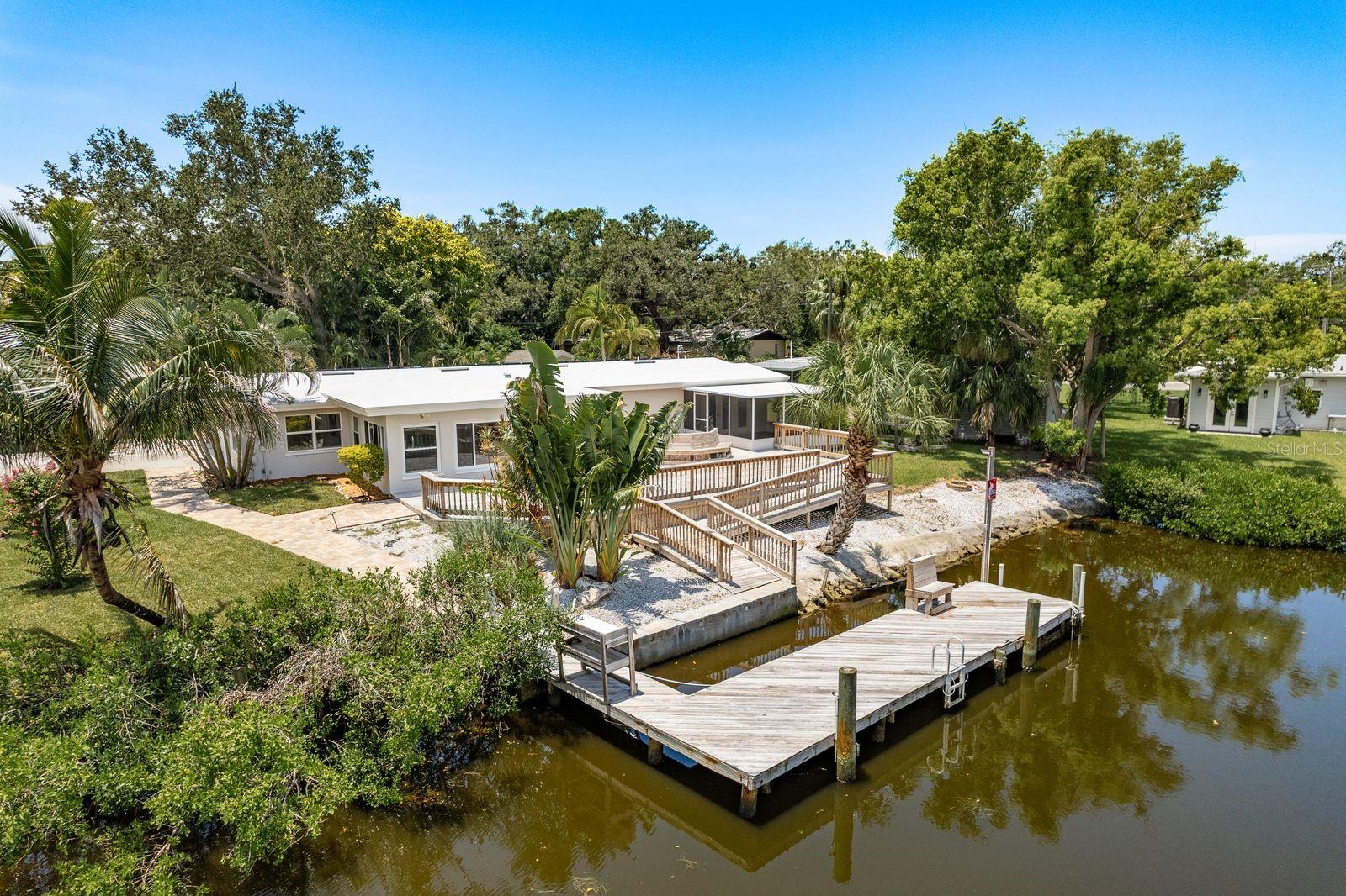 Serious price reduction! Motivated seller! Experience peak Florida living in this tropical, canal-front waterfront home with direct Gulf access (recently dredged canal!!) and no bridge restrictions, located in the highly desirable, golf cart–friendly community of Ozona. This solar-powered 3-bedroom, 3-bath home blends modern upgrades with classic Old Florida charm. Step through elegant double leaded glass entry doors into an open-concept layout featuring high ceilings, crown molding, upgraded lighting, solid wood interior doors, and tile flooring throughout. The spacious living area flows seamlessly into a climate-controlled Florida room overlooking the tranquil water. The updated kitchen is a chef’s delight with custom cabinetry, granite countertops, and brand-new 2025 stainless steel appliances. A separate dining area with recessed lighting and a skylight fills the space with natural light.Two generous guest bedrooms and two full baths (one en suite) showcase beautifully restored vintage tile, with one guest bedroom offering water views and French door access. Privately situated at the rear of the home, the luxurious primary suite features French doors to a screened lanai with canal views, a renovated en-suite bath with dual vanities, an oversized tiled walk-in shower, private commode, and a custom walk-in closet with built-ins and extensive shoe storage. The oversized lot is a true tropical oasis with lush landscaping, privacy bamboo, lemon, lime, orange, avocado, and banana trees, plus fresh sod (2025). Enjoy entertaining on the expansive waterfront deck, relax by the canal, or watch dolphins and manatees from your private dock. Additional features include an electrified storage shed, kayak storage, and a deck pre-wired for a hot tub. Major updates include: Roof (2024), Solar System with transferable warranty (2022), Heat Pump Water Heater (2023), Washer & Dryer (2025), Kitchen Appliances (2025), Upgraded 225-amp Electrical Panel, Newer Windows & Doors, Exterior Paint, and New Front Sod (2025). Ozona is a vibrant waterfront community offering restaurants, breweries, marinas, festivals, and boutique shopping—all just minutes from award-winning beaches, the Pinellas Trail, top-rated schools, and international airports. No HOA or deed restrictions...the ultimate Florida waterfront lifestyle awaits!.