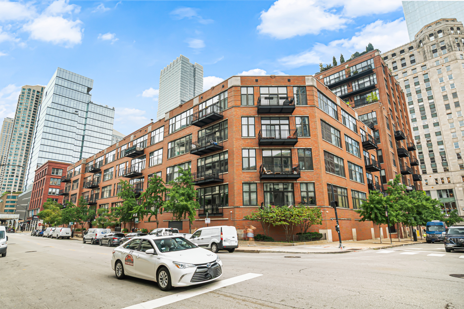 Classic River North loft living at Union Square - a rarely available 1-bedroom, 1-bath condo on the sixth floor with unobstructed city skyline views, soaring vaulted ceilings, and a private balcony in a gated, full-amenity loft building. Inside, oak hardwood floors run through the open living and dining space, anchored by a gas fireplace, exposed brick, and track lighting overhead. Step onto the balcony and the skyline is right there - imagine morning coffee with that view. The galley kitchen holds the in-unit laundry, upgraded with a brand-new GE washer and dryer (2026), and recent improvements carry through the rest of the home: bedroom carpet, bathroom vanity and toilet, kitchen and bath lighting, and blinds - all recently replaced. The bedroom offers a walk-in closet, and the full bath features a deep soaking tub. Union Square is a professionally managed building with full-time door staff, an on-site manager and engineering staff, a receiving room, dry cleaners, a bike room, and additional storage. Monthly assessments cover heat, air conditioning, gas, water, cable, and internet. Translation: electric is the only utility bill left. A heated garage parking space is available for an additional $30,000; anyone who has hunted for gated, heated parking in River North knows how rare that is. Half a block to the Brown Line at the Merchandise Mart and steps to the Chicago Riverwalk, East Bank Club, and the restaurants and galleries of River North, with Jewel-Osco on Desplaines, Fulton River Park, and quick access to I-90/94 nearby. The unit sits in the Ogden Elementary (K-8) and Wells Community Academy High School (9-12) attendance area - the best of city living on a quiet stretch of Hubbard Street.
