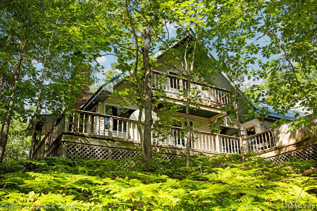 Rare opportunity to own a 440-acre private retreat just minutes from Black Lake. This property offers miles of groomed trails, a cold-water creek running through, and a private pond with observation gazebo. Multiple hunting blinds and abundant wildlife make it a turnkey destination for recreation or sportsman use. A large pole barn provides excellent storage for equipment and outdoor gear.
The 4-bedroom home is designed for comfort and entertaining. Features include a spacious great room with fireplace, main-floor primary suite with walk-in closet, new updated kitchen, and walk-out basement with additional sleeping quarters. The second floor offers two bunk rooms ideal for hosting family and friends.
Outdoor living is highlighted by a wrap-around deck, Hot Springs hot tub, and an  outdoor kitchen space —perfect for gatherings after a day on the trails.
Whether used as a hunting lodge, recreational getaway, or legacy estate, this Northern Michigan property combines privacy, acreage, and modern amenities in one remarkable package.