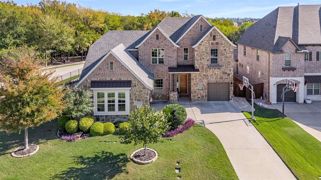 Stunning 4-bedroom, 3.1-bathroom home with 3-car garage, ideally situated on a premium corner with greenbelt views. Located just minutes from Hwy 121, upscale dining, Collin College Technical Campus, and Allen ISD STEAM Center. Zoned for award-winning Kerr Elementary, ranked among the top schools in Texas. Step inside to soaring vaulted ceilings, a dramatic curved staircase, and gorgeous real hardwood floors that flow through the main living spaces. The gourmet kitchen impresses with a large island, KitchenAid 5-burner cooktop, double ovens, recently installed dishwasher, and extended cabinetry into the breakfast area for additional storage and serving space. The spacious living room is filled with natural light and features a stone fireplace with hearth and peaceful views of the greenbelt. Retreat to the private primary suite complete with bay windows, newly installed plush carpet, and a spa-inspired bath offering separate granite vanities, soaking tub, oversized walk-in closet, and recently updated frameless glass shower with bench and niche. A private guest suite with ensuite bath and walk-in closet is conveniently located on the first floor as well making it ideal for multi-generational living or visiting guests. Additional main-level highlights include a dedicated study with French doors, formal dining, mud bench, powder bath, and large utility room with cabinets, plumbed for a sink and space for a second fridge or freezer.
Upstairs offers two spacious secondary bedrooms with walk-in closets and a bathroom featuring an updated quartz dual-sink vanity and private shower area. The game room provides access to a walk-out attic, and the media room includes platform seating and surround-sound wiring for the ultimate movie-night experience. The backyard boasts lush landscaping, an extended covered patio with gas stub for grill and peaceful views of the greenbelt. It’s the perfect setting for morning coffee or unwinding in the evening.