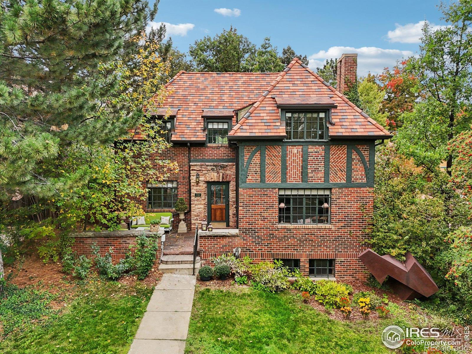 Ideally positioned in the heart of University Hill on one of Chautauqua's widest and most coveted streets, this distinguished 1937 English Tudor showcases timeless elegance and enduring Boulder charm. Rich hardwood floors, gracious living spaces, and abundant natural light create a warm yet refined atmosphere throughout. The main living room is anchored by a stone gas fireplace, while the finished lower level offers versatile living with a wood-burning fireplace and half bath-ideal for guests, media, or additional entertaining space. Honoring its historic integrity, the home has been thoughtfully maintained and enhanced, including a newer custom clay tile roof-a significant six-figure investment designed to endure for decades. Outside, landscaped grounds provide privacy and a serene setting for outdoor living, complemented by an upper-level deck with mountain views. Just steps from CU, Chautauqua trails, and Pearl Street, this exceptional residence blends architectural character, walkable convenience, and long-term value in one of Boulder's most sought-after neighborhoods. Explore the 3D tour and video to experience the lifestyle-welcome home.