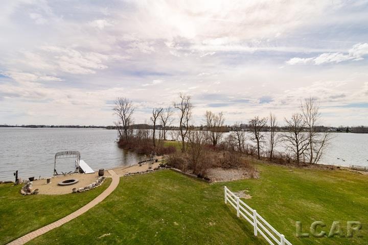 Just over an hour away from Lansing, Toledo, or Ann Arbor this extraordinary waterfront estate invites you to wake up to sweeping panoramic views of Loch Erin from nearly every room. Spanning over 6000 Sq ft., This exceptional retreat is perfectly positioned on a .53 Acre lot with expansive lake frontage. This rare 6 bedroom 4 bathroom home captures breathtaking unobstructed views across the entire lake delivering a truly elevated waterfront lifestyle. Designed for both refined everyday living and effortless entertaining the interior features soaring vaulted ceilings, Expansive skylights that fill the home with natural light, and four fireplaces that create warmth and architectural charm throughout. The thoughtfully designed layout includes 2 luxurious primary suites ideal for multi generational living or hosting guests with comfort and privacy. The finished walkout lower level offers additional living space and entertaining space while the four season room provides a serene setting to enjoy Lakeview's year round. Abundant storage throughout the home ensures both functionality and organization. Outdoor living is unparalleled A sprawling deck overlooks the water creating the perfect backdrop for entertaining, relaxing, or taking in spectacular sunsets. The private beach offers your own personal lakeside retreat while additional storage beneath the deck provides convenient space for all your lake and recreational equipment. Car enthusiast and hobbyists will appreciate the oversized heated garage Complemented by an additional two car garage offering a total of 4/5 garage spaces for vehicles, storage or workshop needs. Adjacent to association owned park the property also enjoys enhanced privacy and open green space further elevating this remarkable setting. -Updates include but not limited to New well in 2021, New furnace and AC in the east wing in 2022, New retaining walls some in 2022 and others in 2024, New lower driveway in 2022, Kitchen update in 2022, flooring update in 2022, Many new Windows and doors, Deck St