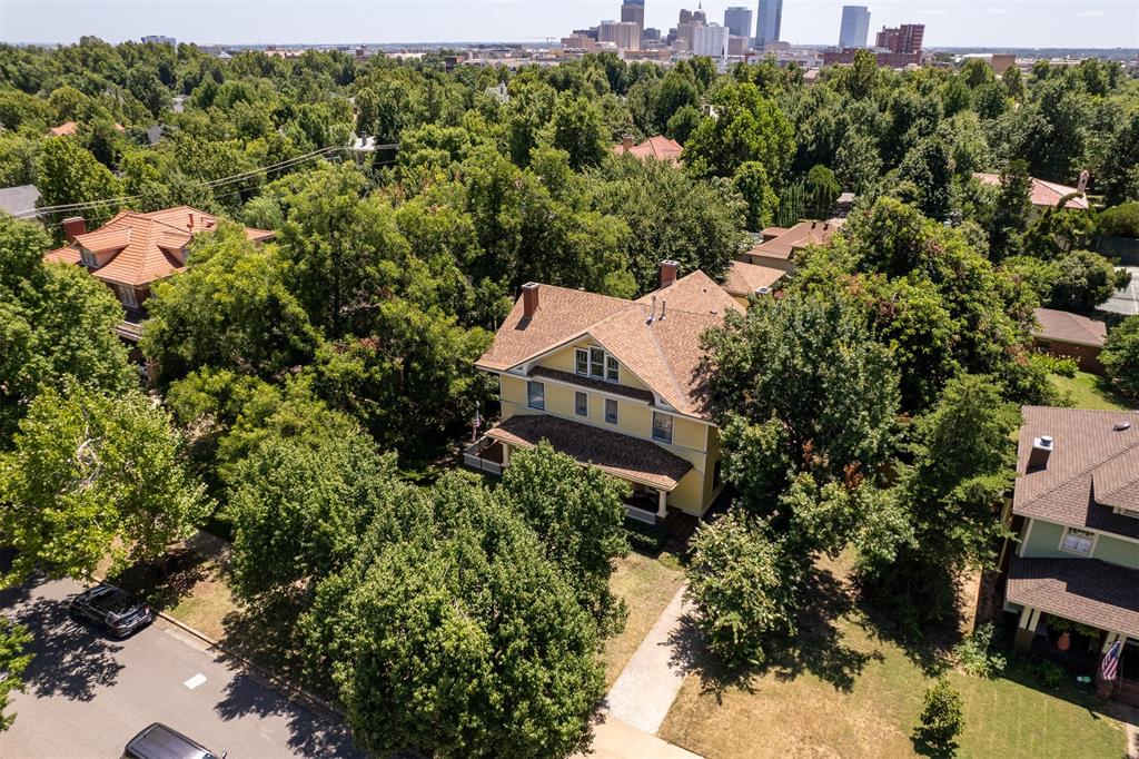 The story of this magnificent home is the story of Oklahoma City. Just two doors down from the former home of Perle Mesta, Oklahoma’s famed ‘hostess with the mostest,’ this beautifully proportioned turn-of-the-century estate occupies an oversized lot brimming with promise. Her façade is classic colonial with a clever twist: a large, Queen Anne-style gable gives the home a dose of flair. Below that, a wide, graceful eave shades the sweeping front porch flanking the front door. You’ll spend a good amount of time here, laughing with neighbors, sipping, reading and watching the world go by. Original tile in the front vestibule and original wood floors add patina throughout the first floor. These floors have not been refinished – ever- and are glorious. Everywhere you look: incredible untouched original paneling and woodwork, antique chandeliers, working fireplaces (five!) and a level of craftsmanship not seen in a century. The home was built by Dr. Thomas and Anna Craven and patients were seen in the west parlor. The formal parlor, to the east of the entry, leads to the sun porch and through to the dining room, big enough to host everyone at the holidays and then some. In the large kitchen, added on in 1924: a sizable island, breakfast room and, be still our historic hearts, the home’s original cabinetry! The finished basement is big enough to be a home theater. The second floor contains more original floors and unsullied woodwork and four bedrooms including a suite. On three is a 900+ sf suite of dreams. Steam shower, massive closet, sitting area, second laundry, built-ins and its own HVAC. The grounds contain the original carriage house and stable, now a two-car garage, a large outdoor living space with deck, hut tub and pergola and enough room to create your dream landscape or a sparkling swimming pool. The sunniest belle of Mesta Park is ready for her next big moment. She’s got great bones. Will you be the one to guide her into her next exquisite chapter?