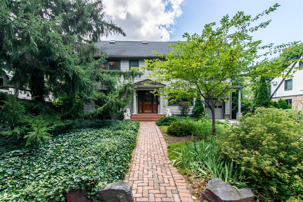 A wonderful opportunity to live in this unique architectural home on a tree-lined street in easy walking distance to the University. French doors, custom-built cabinets, cathedral ceilings in the kitchen and primary suite, and hardwood floors provide charm. Skylights increase the natural light in all three upper floors. The kitchen features tile counters and backsplash, warm cherry cabinets, recessed lighting, and stainless-steel appliances, including two ovens. An eat-in kitchen area overlooks a covered porch and brick patio. Both the third floor and the basement have a full bath and a kitchenette. Mature landscaping enhances the beauty of this home.