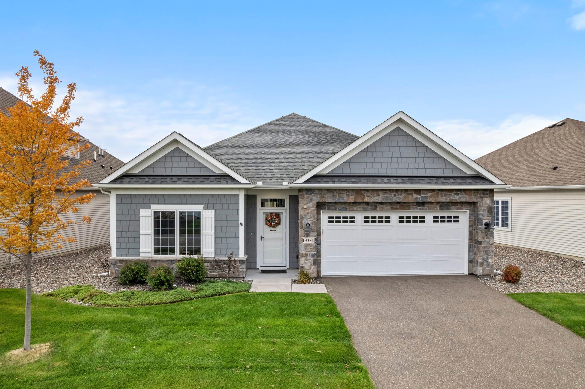 Beautiful, move-in ready home offering effortless single-level living in a peaceful Corcoran setting. Ideally located near golf courses, parks, trails, and abundant outdoor recreation, with quick access to shopping and major roads, blending everyday convenience with a sense of retreat.Step inside to an open, light-filled layout designed for comfortable living and easy entertaining. 9-ft ceilings and expansive windows create a bright, airy atmosphere throughout. The inviting living room features a stunning gas fireplace and serene views of surrounding greenspace, while sleek, continuous flooring enhances the home’s seamless flow.The spacious kitchen is the heart of the home, showcasing quartz countertops, stainless steel GE appliances, a large center island with breakfast bar seating, and a walk-in pantry with generous storage. Nearby, the informal dining area and sunroom shine with vaulted ceilings and abundant natural light, perfect for both quiet mornings and hosting guests.Enjoy the private patio, a perfect extension of the living space, ideal for relaxing or entertaining outdoors. The split-bedroom design offers added privacy, highlighted by a generous primary suite with a walk-in tiled shower, double vanity, and expansive walk-in closet. Two additional bedrooms provide flexible living options, complemented by a full bathroom.Complete with a spacious mudroom, laundry area, large storage area, and attached 2-car garage, this home offers the perfect blend of comfort, functionality, and effortless living.