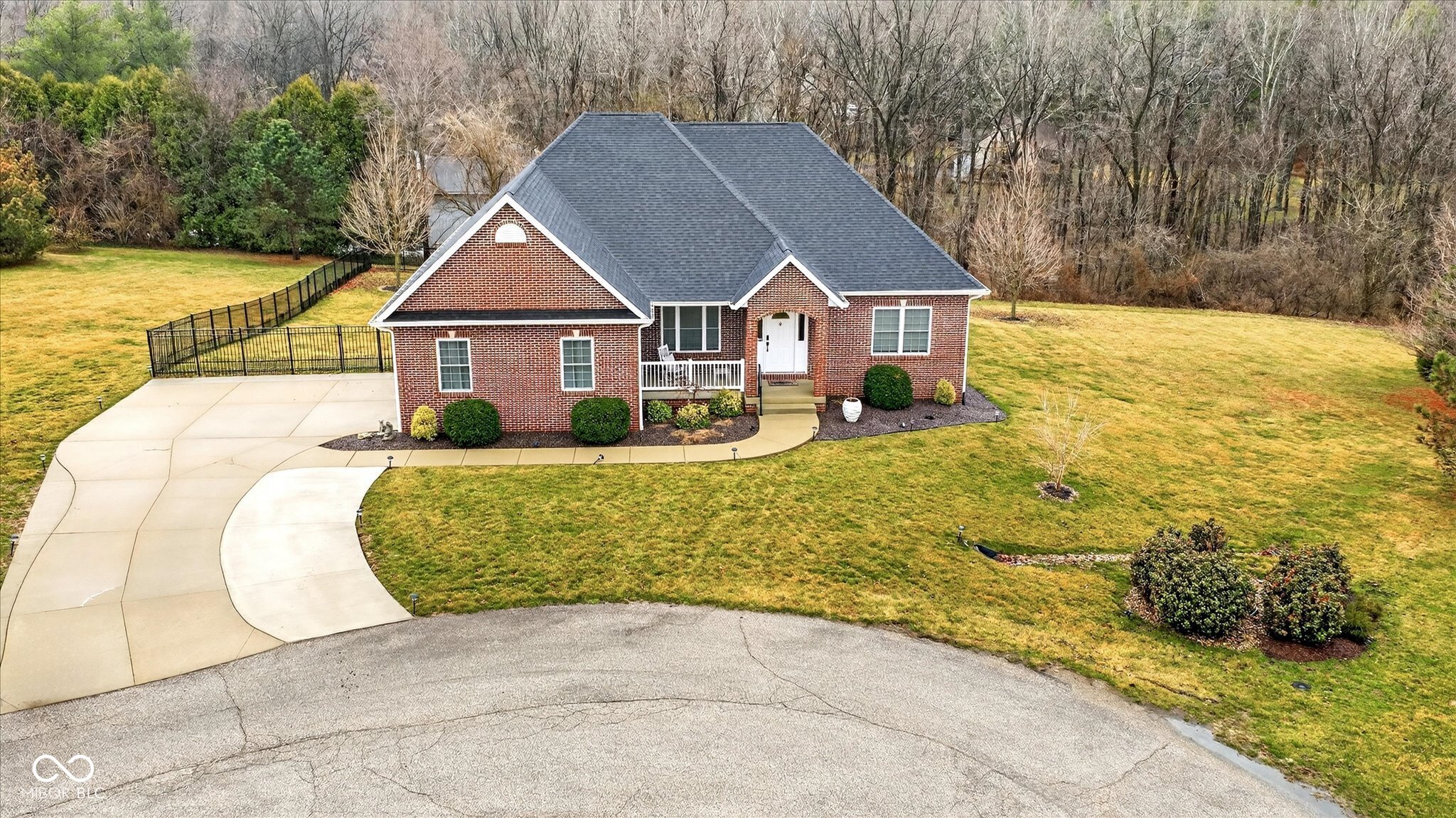 Situated on a quiet cul-de-sac, this exceptional home is set on a beautifully landscaped 1.2-acre lot with a fenced backyard and scenic rear views. The main level includes a primary suite, a second bedroom, formal dining room, den/office, and spacious laundry room. The open-concept living area features a fireplace and flows into a remodeled kitchen with granite countertops (2024). Step outside to enjoy the double rear deck with access from both levels, including a 21' x 13' screened-in porch. With ample indoor and outdoor living space, a fenced yard, and a flexible layout, this home offers something for everyone.    2025 Updates: New paint on the upper level, a whole-house generator, and a large beverage refrigerator in the pantry.    2024 Updates: New kitchen, upper patio with screened-in porch, saltwater hot tub, natural gas line for grill, upgraded electrical panel, and electric heated floors in the lower level. Additional updates include a soundproof studio, 20x14 outbuilding, expanded driveway, and Gator guard garage floor.    2023 Update: New roof.    2022 Updates: New upper patio and staircase, saltwater hot tub, and natural gas line for grill.