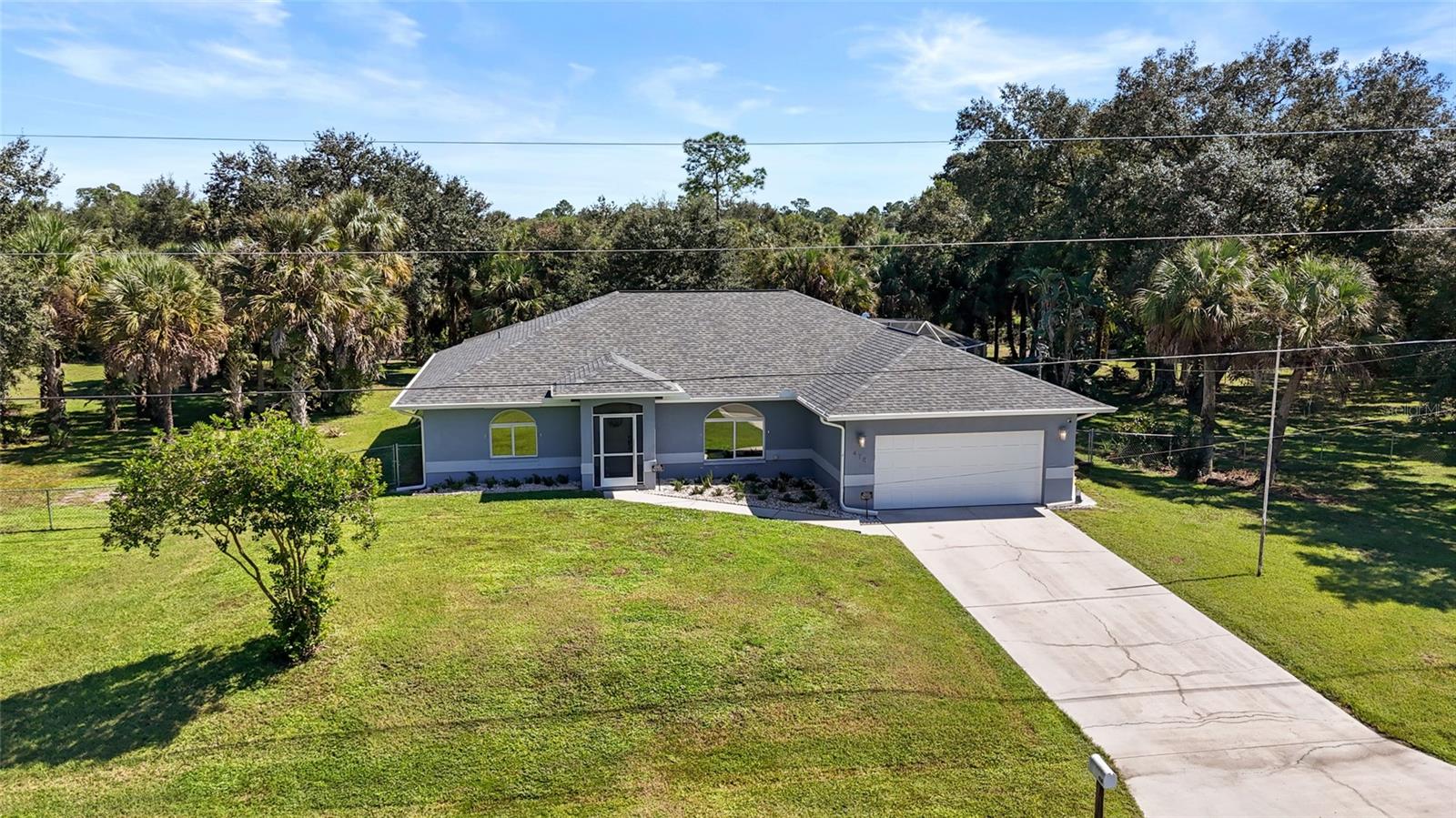 Gorgeous, sprawling 1.5-acre parcel where majestic oaks canopy the property and create the most peaceful backdrop for this well-maintained 3-bedroom, 3-bath pool home with a 2-car garage. Inside, the open-concept living space features soaring vaulted ceilings, pocketing sliders that open to the outdoors, battery-operated Lutron shades in the great room and dining room, and a spacious kitchen with a breakfast bar that flows easily into the dining and living areas. The split-bedroom floor plan offers large bedrooms including two en-suites, with pocketing sliders in the primary bedroom, and all three baths have been updated with NEW vanities. Tile and carpet flooring throughout, plus Lutron Caseta lighting control. Out back, the expansive covered lanai and NEW paver pool deck are made for entertaining, and the oak trees are perfect for swinging and climbing. The permitted, fully fenced backyard has a park-like feel, with landscape lighting, irrigation, and so much opportunity to make this great property your own. Peace of mind comes standard with a BRAND NEW roof, Storm Smart Armor Screen hurricane protection, a NEW impact-rated garage door, a GenerLink (LCEC) transfer switch, re-piped plumbing, water heater (2024), and HVAC (2016), plus well, septic, and a water filtration system. Enjoy a great central location close to parks and recreation, grocery stores, restaurants, and more, with no HOA. Don’t miss this rare acreage pool home!
