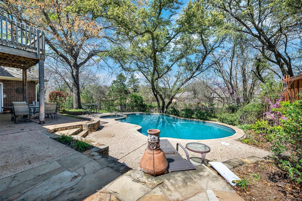 Highly prized residence in Pitman Creek Estates, nestled in the heart of Plano. Situated on an oversized creek lot with the creek running along the backyard, this exceptional property offers privacy, mature trees, and a peaceful natural backdrop rarely found in the area.The backyard retreat features a crystal-blue pool, expansive green space, and covered entertaining areas designed for year-round enjoyment. Towering trees surround the yard, creating a serene setting ideal for both hosting gatherings and relaxing evenings at home.Inside, soaring ceilings and rich hardwood floors set a tone of warmth and sophistication. Custom built-ins surrounding the fireplace create a stunning focal point in the main living area, making indoor entertaining just as inviting as outdoor living.The spacious kitchen offers a large island and eat-in breakfast area overlooking the backyard. Seamless flow between the living room, dining room, and oversized family-play room enhances the home’s indoor-outdoor lifestyle appeal.The expansive family room includes a wine cellar and wet bar, adding versatility and elevated entertaining potential.This two-story home offers 4 bedrooms and 3 baths and is located on a quiet street within walking distance to Westwood Park, featuring a playground, sports fields, basketball court, and scenic walking trails. Zoned to the highly sought-after Plano ISD, this property delivers an exceptional combination of location, comfort, and lifestyle.