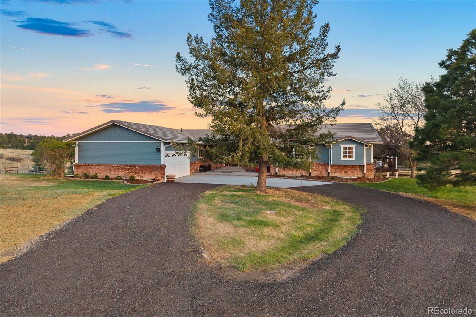 Sunrise stretches across the Front Range while Pikes Peak glows at dusk, and from your wrap-around deck, you have a front-row seat to all of it. This beautifully renovated ranch on 5 quiet, pine-framed acres in Butterfield welcomes you home the moment you step through the door. A wood-burning fireplace, natural oak hardwood floors, and picture-perfect views greet you in the great room, which flows effortlessly into the dining room and a remodeled kitchen with gas cooktop, new appliances, and walk-in pantry. Down the hall, designer finishes and gorgeous alder woodwork frame peaceful views at every turn. The spacious primary suite offers a private deck, abundant walk-in closet, and spa-like bathroom with multi-head walk-in shower, heated tile floor, and soaking tub with sweeping mountain views. A second bedroom offers a charming built-in window bench and beautiful natural light. Granite and marble countertops and Alpen windows in the bedrooms elevate everyday living. Downstairs, a new-construction walk-out basement feels like a home within a home: expansive family room with gas fireplace, stunning kitchenette with quartz counters and walk-in pantry, two bedrooms, an office ready to be a 5th bedroom, two bathrooms and heated floors, and new WeatherShield windows throughout.  Movie nights for everyone or family moving closer? This level delivers. Outside, you're home on the range in the best way. Deer and antelope wander the neighborhood, but your irrigated garden is protected by an 8-foot fence. Unwind in the Wind River hot tub or gather on the lower paver patio. A 4-stall barn with tack room, power and water, and fully fenced property welcomes horses! The entire 5 acres are enclosed with a buried electric dog fence. Tucked into a quiet neighborhood, minutes to Colorado Golf Club and Parker's vibrant shopping, dining, and entertainment, every morning is simply you and nature’s beauty. This is the one you’ll want to call home.