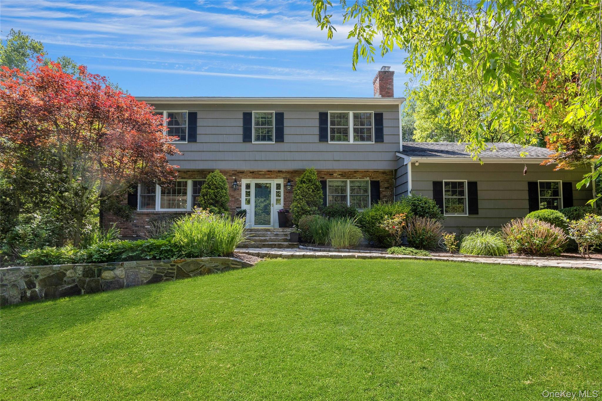 Set on a beautifully landscaped and level 1.5 acre property, this classic 4-bedroom Center Hall Colonial offers the perfect combination of privacy, space, and convenience. A Belgian block-lined driveway welcomes you to this meticulously maintained home, ideally set back from the road and surrounded by mature landscaping. The main level features a lovely living room flowing seamlessly into the formal dining room, an eat-in kitchen with a family room, along with a private home office. Sliding doors off the kitchen open to a deck overlooking the expansive backyard, creating an ideal setting for entertaining or everyday enjoyment. Upstairs, the home offers 3 nice sized bedrooms, a primary suite plus a flexible office/den space perfect for working from home, studying, or relaxing. The finished lower level provides additional living and entertaining space with a gym, full bathroom, abundant storage, and walkout access to the backyard. Ideally located just minutes from downtown Armonk, parks, shopping, dining, and the North White Plains train station for an easy commute to New York City, this exceptional property offers the best of suburban living.