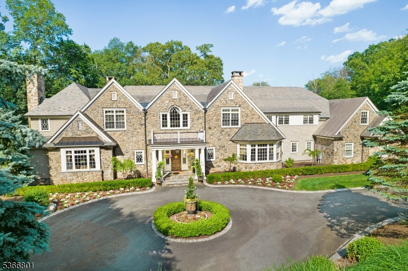 Set within Mendham's prestigious Roxiticus enclave, this extraordinary 23+ acre estate offers timeless elegance, total privacy, and resort-style amenities. Featuring 7 bedrooms and 7.3 bathrooms, the custom home showcases classic architecture, modern comforts, and expansive, beautifully finished living spaces. Highlights include a chef's kitchen with high-end appliances and butler's pantry, formal living and dining rooms, a fireside great room, private office, guest suite, and radiant heat throughout much of the home. The luxurious primary suite BOAsts a sitting room, dual spa-like baths, two walk-in closets, and fireplace. The fully finished walk-out lower level is an entertainer's dream with a wine cellar, full bar, gym, theater, game room, and radiant-heated recreation space with access to a private slate patio. A heated 4-car garage offers exceptional utility and design. Outside, enjoy a sweeping bluestone terrace, manicured lawns, direct access to Schiff Preserve, and room for a future custom pool (plans available). A rare legacy estate blending refined living and natural beauty in one of Mendham's most prestigious locations.