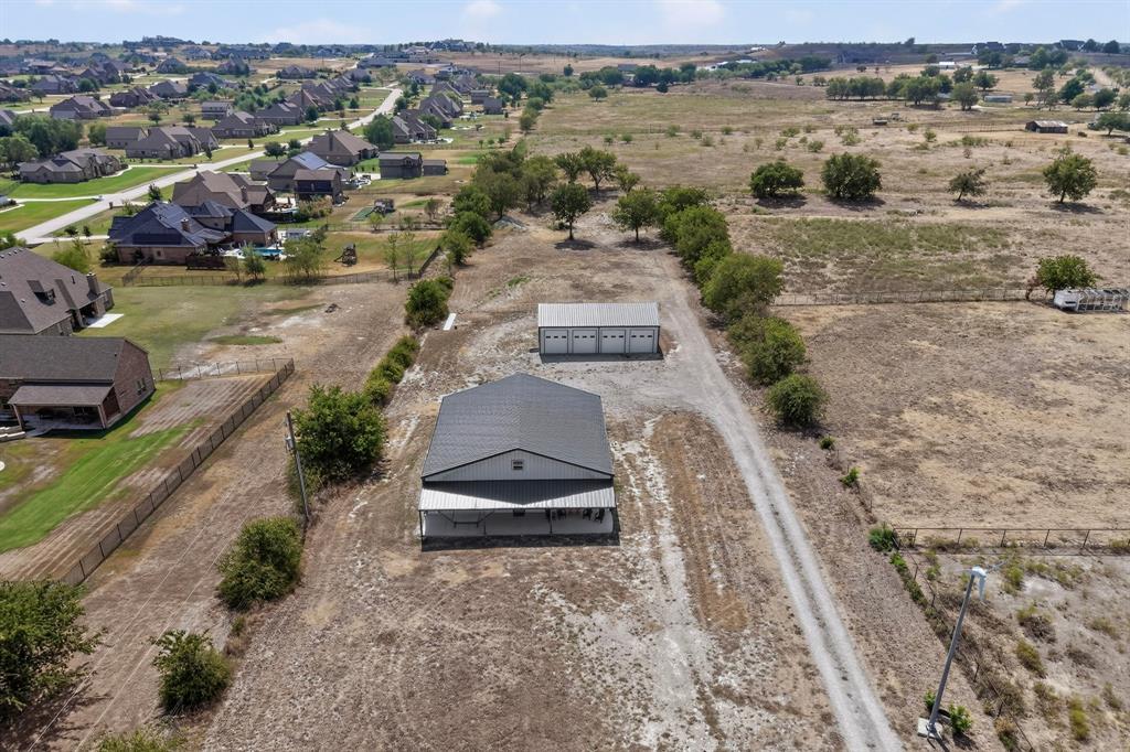 Welcome to your peaceful country retreat on 3.024 acres in the desirable south side of Annetta, just outside Aledo. Enjoy the space and tranquility of country living while remaining within an approximately 35-minute commute to downtown Fort Worth. Inside, the open-concept design features high ceilings and a spacious central living area that flows seamlessly into the dining space and kitchen, creating a versatile setting for everyday living and entertaining. The home offers four bedrooms, and 2 full bathrooms, including a spacious primary suite with a private ensuite bath featuring a large walk-in shower and oversized walk-in closet. Each bedroom includes a walk-in closet, while the flexible layout provides a versatile room that could easily serve as a formal dining area, family room, home office, hobby space or additional living area. Step outside to enjoy expansive covered front and back porches, perfect for relaxing and taking in the peaceful surroundings. A standout feature is the impressive 1,500-square-foot, four-door garage and workshop with a half bath and 10-foot garage doors, offering abundant room for vehicles, equipment, hobbies, storage or more! With generous acreage, flexible living spaces and exceptional shop space, this property offers the freedom and functionality of country living with convenient access to Fort Worth and Aledo.