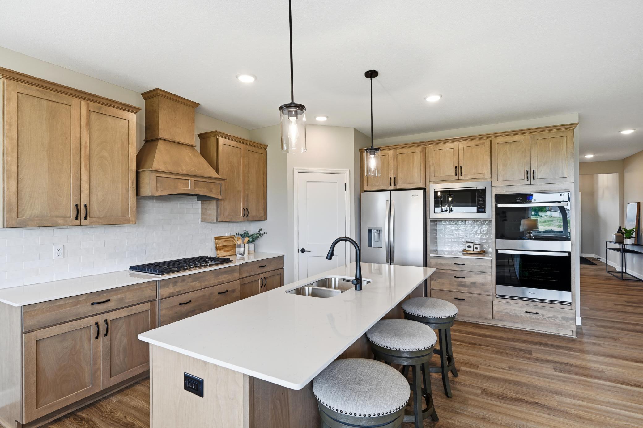 Luxury isn't always about having more, sometimes it's about living with greater ease. Welcome to the Somerset by JP Brooks, where thoughtful design, elevated finishes, and effortless main-level living come together to create a home you'll love for years to come.Imagine beginning each day in a sun-filled owner's suite, enjoying coffee in your gourmet kitchen, and ending the evening by the fireplace with the people who matter most. Every detail of this home has been intentionally designed to make everyday living feel both beautiful and uncomplicated.At the heart of the home is a stunning open-concept living space featuring vaulted ceilings that create an airy, welcoming atmosphere. The gourmet kitchen is as functional as it is beautiful, complete with quartz countertops, an impressive 8-foot center island, stainless steel appliances, a wood vent hood, 42-inch upper cabinetry, walk-in pantry, and thoughtful details that make cooking, entertaining, and gathering feel effortless.The spacious main-level owner's suite offers a private retreat with vaulted ceilings, a luxurious ensuite featuring a soaking tub and separate shower, and a generous walk-in closet. Main-floor laundry adds another layer of convenience, allowing daily routines to remain simple and efficient.Downstairs, the finished walkout lower level expands your living space with a second fireplace, an oversized family room, additional bedrooms, a full bath, and plenty of room for guests, hobbies, movie nights, or multi-generational living. Whether you're hosting family for the holidays or simply enjoying a quiet evening at home, you'll appreciate the flexibility this thoughtfully designed space provides. The expanded three-car garage with a workshop area offers extra room for projects, storage, or recreational gear, while the walkout homesite enhances both natural light and outdoor living.Located in Meadowbrook, one of Monticello's newest communities, you'll enjoy a peaceful neighborhood setting with convenient access to Interstate 94, Highway 25, shopping, restaurants, parks, and local schools. It's a location that offers the perfect blend of everyday convenience and small-town charm.The Somerset isn't simply designed for one level of living, it's designed for every stage of life. Beautifully crafted, thoughtfully planned, and move-in ready, this is a home where comfort, quality, and timeless design come together effortlessly. Schedule your private tour today and experience the difference for yourself.