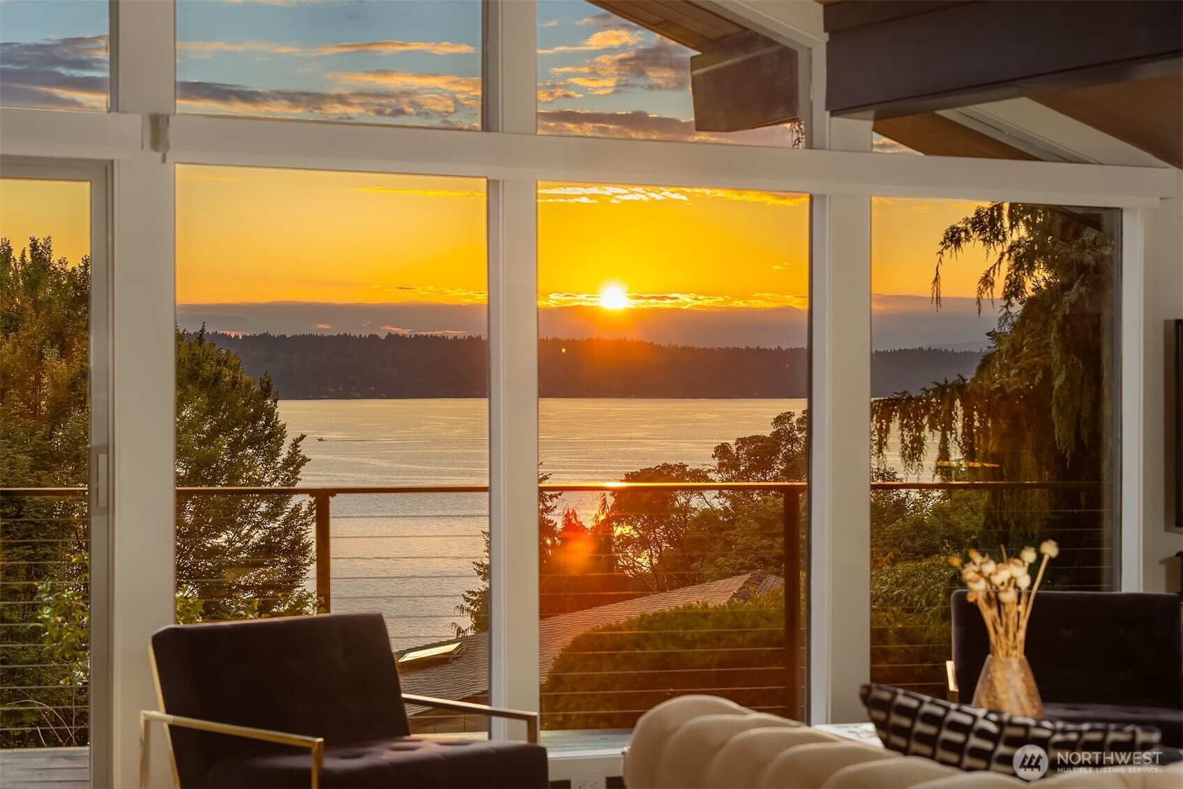 Rare one-level living with panoramic Puget Sound and Olympic views and your own private beach - this must be the place! The midcentury wow-factor is in full effect at this custom architect-designed home, with vaulted cedar ceilings and walls of West-facing windows framing water, mountains, and islands. The main floor lives entirely on one level with step-free access from the carport. A NW Contemporary work of art that has been carefully improved while maintaining its character: A basalt fireplace anchors the open living space - one of three gas fireplaces - while expansive decks and a sheltered patio invite seamless indoor-outdoor living. Updates include hardwood flooring throughout, stunning new main floor bathrooms, fresh paint, and a heat pump for A/C. Ride the elevator down to a lower level ADU to find a second kitchen, full bath, sunroom, and private entrance and parking area. Excellent as a guest unit, studio, office, independent living space, or for rentable income. Head outside to enjoy a quarter-acre+ of professionally landscaped, terraced spaces for sunset viewing, gardening, and cocktail hours, with room to create additional level yard space below. The serene waterfront community of Seahurst West welcomes you, ensconced in a quiet cul-de-sac setting with a community beach and kayak launch a short walk down the lane. CC&Rs allow trees to be trimmed to protect your view. Minutes to Olde Burien's excellent restaurants, an easy commute to Seattle… and a world away.