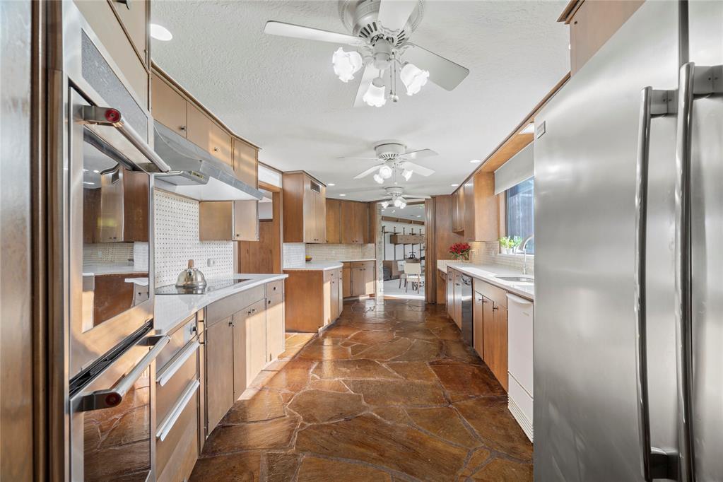 Step into a world of architectural splendor & timeless elegance with this Frank Lloyd Wright-inspired estate, offering nearly 8,000sqft (MOL) of meticulously crafted living space. Built in 1969 & thoughtfully expanded, this residence seamlessly blends mid-century modern design with luxurious amenities, creating a one-of-a-kind home that caters to both comfortable multigenerational living & grand entertaining. As you approach, a curved driveway & porte cochère set the tone for the grandeur within. You are welcomed w/a two-story foyer featuring a spiral staircase, leading to a library & great room with custom built-ins, wood-burning fireplace, & views of the solarium—a lush indoor greenhouse perfect for year-round gardening. Adjacent is a private bar room, ideal for entertaining! The NE wing of the home is dedicated to shared spaces, including a kitchen that serves as the heart of the home. Boasting a unique curved design, original cabinetry, quartz countertops, & walk-in pantry, it flows seamlessly into the formal dining, which is enveloped by the striking stone walls of the grand staircase. The SW wing of the main house hosts 4 spacious bedrooms, each with ensuite baths & ample closets. The primary suite offers a private office/sitting area, ensuite bath w/ dual vanities, & cedar closet. Upstairs, you'll find versatile bonus spaces, including a potential bedroom w/a ensuite bath & a NEW rooftop observation deck that delivers breathtaking views of Downtown OKC, Tinker AFB, & stunning Oklahoma sunsets. The connected 2,600 sqft guest wing is a haven of its own. Designed for harmonious co-living, it features a second kitchen, dining & living areas, a large primary suite w/a walk-in closet & ensuite bath, a flexible second room, and 2 full baths. With a separate entrance, it’s perfect for multigenerational living or private guest accommodations. The outdoor experience is equally remarkable, with 5 sprawling acres, a heated saltwater pool, swim-spa, & a 30x40 shop.