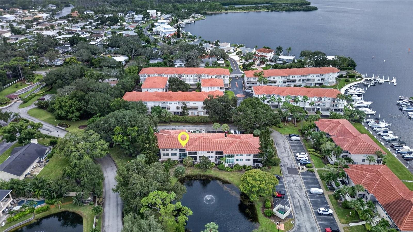 MOVE-IN READY, BEAUTIFULLY UPDATED, AND SOLD FURNISHED! Welcome to effortless Florida living in this beautifully updated second-floor condo in the heart of Tarpon Springs! Situated high and dry, this charming retreat offers the perfect combination of modern upgrades, low-maintenance living, and an active & amenity-rich community. Step inside to discover a gorgeous updated kitchen with newer appliances, stylish luxury vinyl flooring, updated bathroom vanities, and an enclosed sunroom perfect for relaxing with your morning coffee or unwinding after a day of fun overlooking a beautiful community pond and fountain. NEW HVAC 2026 with a 10-year warranty and a newer water heater. BEST OF ALL, THIS CONDO COMES FURNISHED! Just bring your suitcase and start enjoying your new home! There's so much to do in this community from tennis and pickleball courts, community pool, walking trails, relaxing hot tub, clubhouse, and a calendar full of social events. A 24-hour guarded entrance provides an added level of security and peace of mind. Monthly fees cover an impressive list of services, including water, cable, internet, escrow reserves, exterior grounds and building maintenance, pool maintenance, and trash service, making everyday living a breeze! Whether you're searching for a full-time residence or seasonal Florida getaway this condo checks all the boxes. UPDATED, FURNISHED, AND READY FOR YOU TO ENJOY. Only minutes to world famous Sponge Docks, Innisbrook Golf Resort, local restaurants and shopping -  JUST MOVE IN AND START LIVING THE FLORIDA LIFESTYLE!