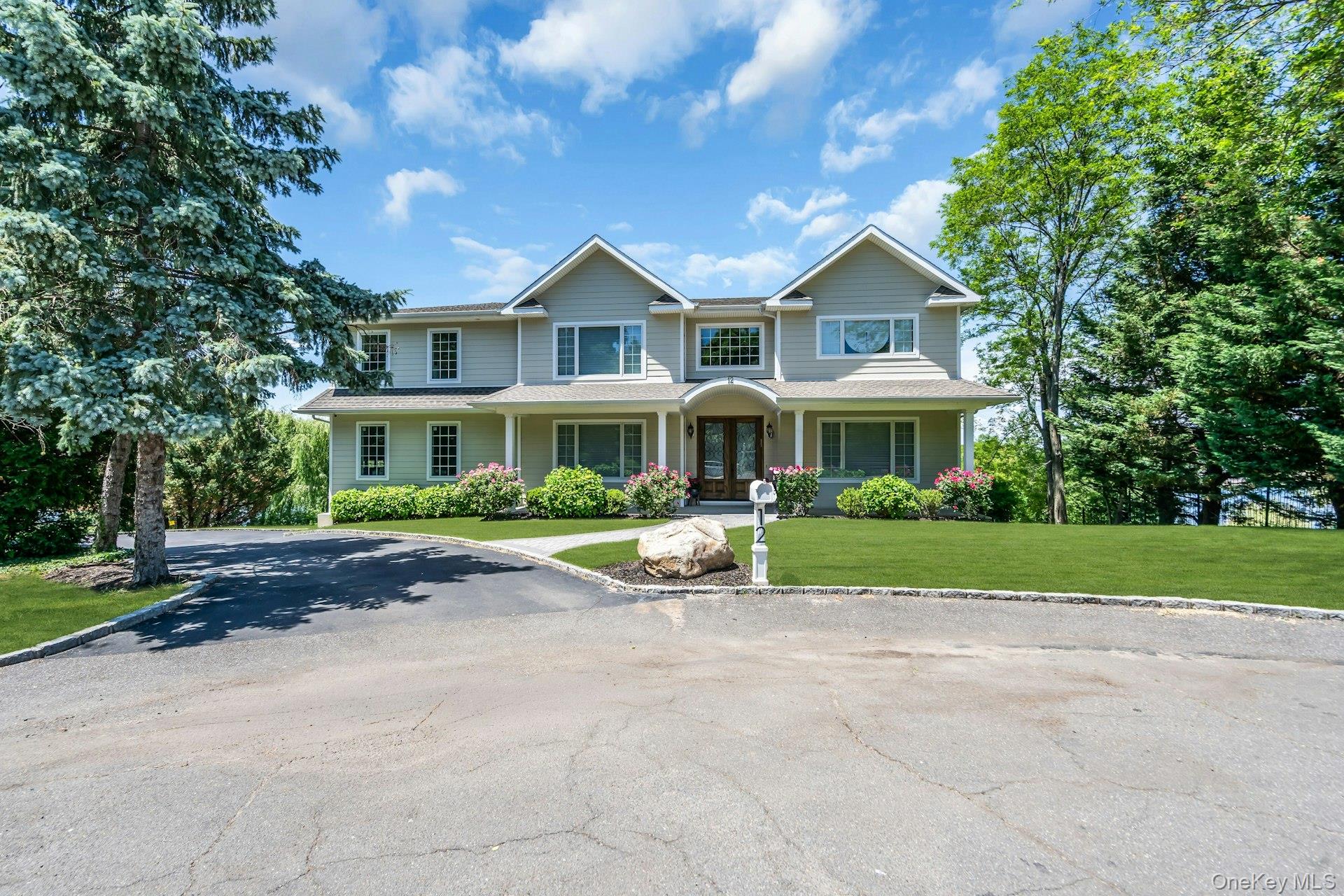 Tucked away at the end of a quiet cul-de-sac, on just under one acre, this exceptional waterfront Colonial offers over 7,200 square feet of thoughtfully designed living space with captivating views of Dosoris Pond and the Connecticut shoreline beyond. Built in 2019 as the builder’s personal residence, every detail reflects superior quality, craftsmanship, and attention to design. Featuring 6 bedrooms and 7.5 bathrooms, the home is filled with natural light, highlighted by expansive windows, detailed millwork, and elegant architectural finishes throughout. The gourmet kitchen anchors the main level and opens seamlessly to both formal and informal living spaces, creating an ideal setting for entertaining and everyday living. The luxurious primary suite serves as a private retreat, complete with generous walk-in closets, a spa-inspired bath, and a private balcony showcasing panoramic water views and unforgettable sunsets. A standout feature is the 2,400-square-foot finished lower level with soaring 12-foot ceilings, offering endless flexibility for a home theater, fitness studio, game room, or additional entertaining space. Designed for year-round comfort and efficiency, the home is equipped with a three-unit central HVAC system with three-zone climate control, allowing for personalized temperature settings throughout the residence. Additional amenities include Energy Star-certified construction, radiant heated floors, smart home integration, 300-amp underground electric service, a hardwired 4K security system, professionally landscaped grounds, and direct pond access. Combining waterfront tranquility with modern comfort and exceptional construction, this one-of-a-kind residence offers a rare opportunity to enjoy luxury living in one of Glen Cove’s most desirable and private settings.