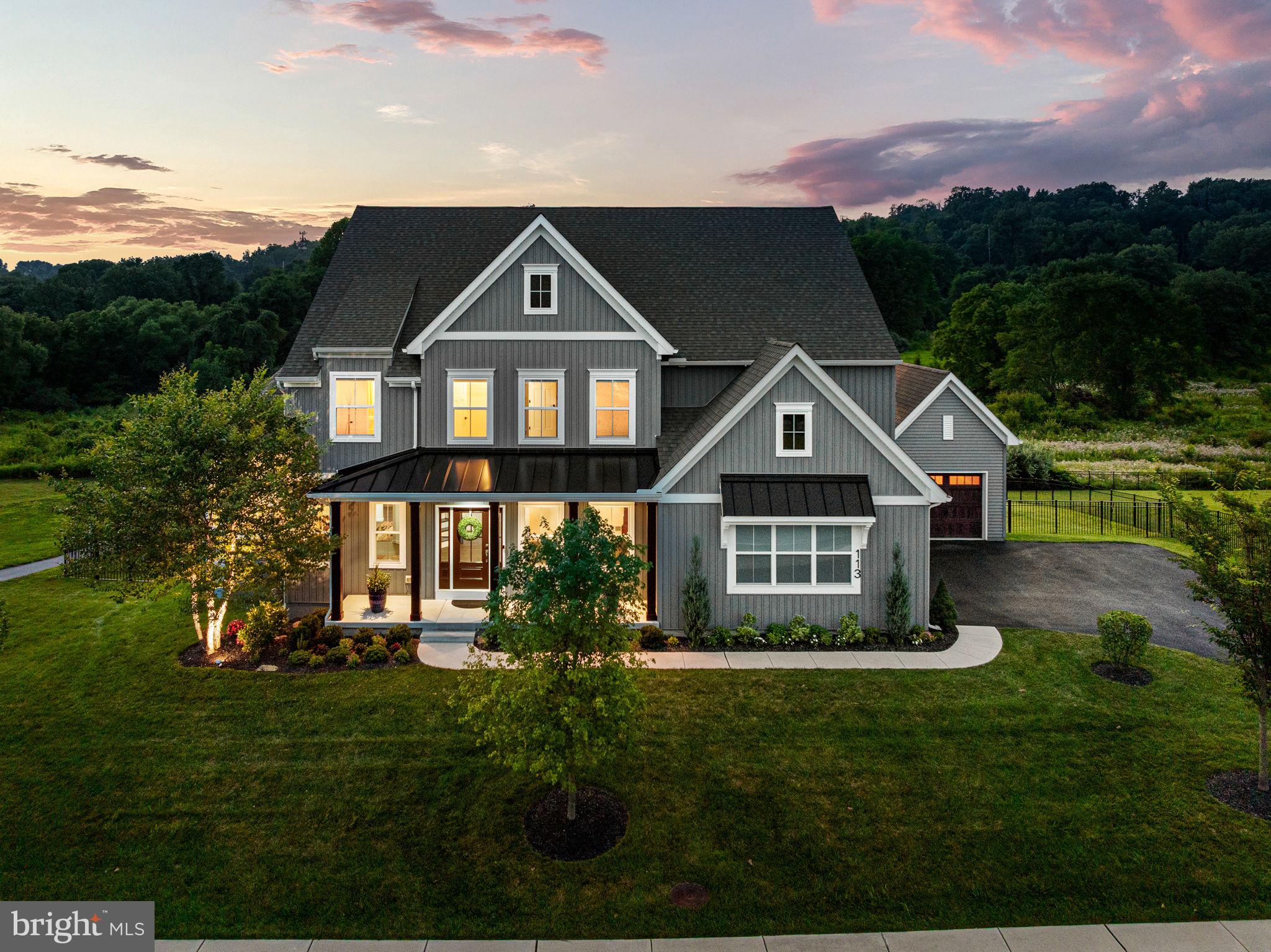 Built in 2022 by Keystone Custom Homes, this exceptional Devonshire Farmhouse model offers the perfect blend of timeless design, luxury finishes and an unparalleled setting. Situated on a premium lot overlooking a tranquil nature preserve  and picturesque pond, the home provides over 5,700 square feet of beautiful living space, including 4,600 square feet above grade and an additional 1,100 square feet in the walkout lower level. With 4 spacious bedrooms,4 full baths, 2 half baths and the flexibility to create a 5th bedroom or guest suite on the main level, this residence accommodates both everyday living and elegant entertaining. The home’s curb appeal begins with a welcoming covered front porch and continues into an inviting interior featuring luxury plank flooring, a dramatic open staircase with wrought iron balusters, spacious dining room, conservatory, sitting room, library nook, and a spectacular 2-story family room with coffered ceiling anchored by a soaring stone gas fireplace. A wall of windows fills the space with natural light while framing peaceful views of the surrounding open space.The gourmet kitchen is a true centerpiece, showcasing premium KitchenAid appliances, a Bosch refrigerator, a massive 5’ x 10’ center island with storage on both sides, a dedicated coffee bar, upgraded white shaker cabinetry with soft-close doors+drawers, quartz countertops with matching backsplash, a Kohler farmhouse sink, and under-cabinet lighting thru out. A bright breakfast area opens to the rear deck, creating seamless indoor-outdoor living, while the adjacent butler’s pantry with beverage refrigerator provides additional convenience for entertaining.Upstairs the luxurious primary suite serves as a private retreat, complete with a tray ceiling, ceiling fan, custom his-and-her walk-in closets by Diplomat Closet Design, a beautifully appointed Venetian-style bath with upgraded tile & flooring. Three additional bedrooms each feature their own private en suite baths and walk-in closets. A convenient second-floor laundry room with utility sink and back stairs leading to first floor vestibule, adds thoughtful everyday functionality. The walkout lower level expands the home’s versatility with over 1,100 finished square feet, a powder room, generous storage areas, and an upgraded window-door package that opens directly to the outdoor entertainment space, allowing natural light to pour in while connecting the interior to the backyard oasis. Outdoor living is truly exceptional. The custom-designed rear entertaining area features a spectacular 1,068-square-foot flagstone patio built over a concrete base, complete with a wood-burning fireplace, partial knee wall with bluestone seating cap, low-voltage landscape lighting, and a waterproofed deck overhead for year-round enjoyment. The elevated TimberTech deck is finished with PVC-clad posts, stainless steel cable railings, and stair lighting, creating a sophisticated outdoor space perfect for relaxing or hosting gatherings. A fully fenced backyard, mature lawn, professional landscaping and complete irrigation system further enhance the property’s appeal. Additional upgrades include a 3 Story angled bump-out serving the lower level, breakfast area, and primary suite, a side-load 2-car garage with an additional 1 car bay, two-zone HVAC, a fully sprinklered interior, upgraded rocker switches with screwless cover plates and USB outlets, a Vivint security system with outdoor cameras & remote monitoring. Located within a vibrant, family-friendly community, residents enjoy resort-style amenities including a clubhouse, swimming pool, fitness center, sport courts, party rooms, scenic walking trails, and an active calendar of neighborhood events. Combining exceptional craftsmanship, luxury amenities and an idyllic natural setting, 113 Parkview offers a rare opportunity to enjoy refined living in one of the area’s most desirable communities.