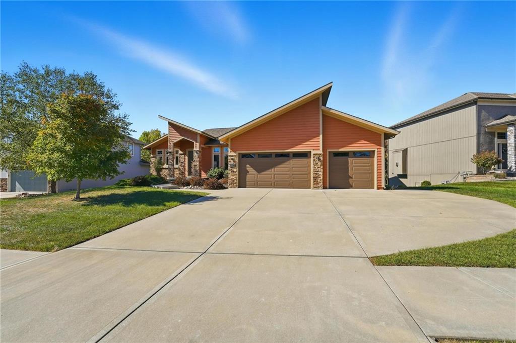 Exceptional custom home designed with entertaining in mind. Stunning walnut floors from the gracious entry, through the great room, kitchen & breakfast room. Great room has vaulted ceiling, gas fireplace in stone accent wall, built-ins & floating shelves. Kitchen has large island, top of the line appliances including built-in Frigidaire Professional refrigerator/freezer, cooktop with vented hood, dbl oven, microwave & dishwasher. Pantry is 5x16 with built in desk under window, tons of shelf space. Breakfast nook is ideal for banquet, full glass door out to Lanai, vaulted ceiling, ceiling fan. Bonus main level family room has 19' bar w/custom cabinets, granite counters, stone walls behind bar, 2nd 15' long serving bar with tons of storage, granite countertop & mid century design. Family room has 15' vaulted ceiling with tongue & groove ceiling & beams. A beautiful den space, or room for baby grand piano, under the beautiful fixture plus additional dining space surrounded by windows & door out to large covered Lanai with tile floor. The primary suite is large with vaulted ceiling & luxury bath with separate vanities, very large tiled shower, dream 10x18 walk-in closet with large dresser island, walks through to laundry. Staircase to lower level with custom glass panel railing, large windows flooding the stairway with natural light. Large family room with wet bar area with tiled floor. 1 guest suite with bath & large walk-in closet, 2 additional bedrooms have walk-in closets, each with private vanity spaces, share shower. 1 bedroom has a secret passageway through built-in bookcase, to 8x9 storm area/storage under front porch! New covered patio off lower level family room is 20x13. Car lovers, a bonus 4th garage, has driveway from main level, is 22'd x 19'w. The main level 3 car garage is oversized, 31'wide, with 11' ceiling, 2 car side is 24'deep, 1 car side 29'deep with 9' wide door. North Shore is Cass County, Lee's Summit Schools.