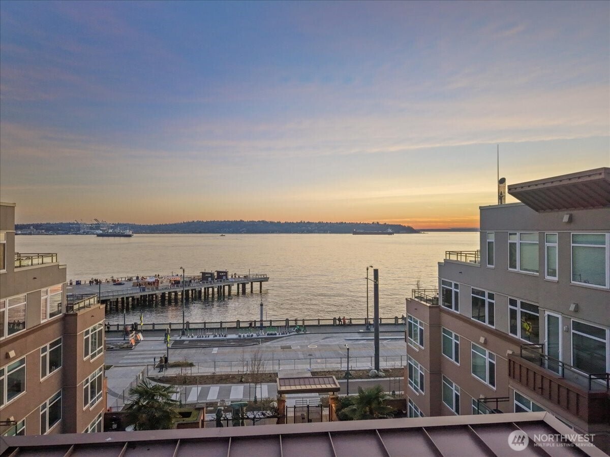 Rare ground-floor waterfront condo w/ private terrace in the coveted Waterfront Landings. Unlike typical condo balconies, this oversized terrace offers a rare and usable outdoor retreat with amazing waterfront and sunset views — an extension of your living space perfect for morning espresso, curated container gardens, intimate gatherings, or unwinding in the fresh Puget Sound air.     Inside, an open-concept design is elevated by abundant natural light and a seamless flow between living, dining, and kitchen spaces. Fresh designer paint, new appliances, and updated countertops with a modern backsplash that feels both timeless and move-in ready. The thoughtful floor plan balances openness with privacy, offering comfort without compromise. Two secure garage parking spaces add exceptional convenience and value, along with access to a dedicated hobby room for additional flexibility.     Residents enjoy a full suite of resort-inspired amenities: 24/7 concierge service, a fully equipped fitness center, hot tub and sauna, rooftop terrace with BBQ and sweeping views, and a private guest suite available for guests. Secure entry ensures both privacy and peace of mind.    Just steps from Waterfront Park, Pier 62, Pike Place Market, acclaimed dining, ferries, and downtown conveniences, this residence offers a refined blend of vibrant urban living and tranquil waterfront ambiance.    No rental cap, making this an exceptional opportunity for discerning homeowners or strategic investors.