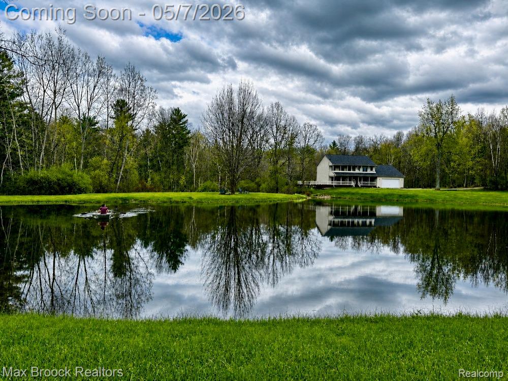 If this place doesn't take your breath away -- not much will. You can hear the creek right from the primary bedroom balcony—crack the windows, let the breeze in, and fall asleep to the sound of running water. Spend your days fishing, swimming, or kayaking on your own spring-fed pond—over an acre with a sandy beach that feels more like your own private lake than a backyard. This is one of those places that doesn’t feel like a house—it feels like a private resort. Nearly 16 acres gives you options… hunt, bring the horses or livestock, or just enjoy the peace and space. The wraparound porch on both levels gives it that timeless southern feel, like something out of a different era. About 75% of the property is wooded with mature hardwoods, and groomed trails wind all the way through it. There’s a creek running across the land with a wooden bridge over top, and even a natural cascade over the rocks that feels like your own little waterfall. It’s totally private. Gated. Tucked at the end of a dead-end/private road. The kind of place you don’t stumble across twice. The home itself has been completely renovated over the last two years—top to bottom—and lives like new construction. Finished basement gives you an abundance of additional living space. Award-winning North Branch Area Schools, just 8 miles to I-69 for an easy commute, and high-speed internet already in place. This isn’t just a property -- it's a change your life type home. *Professional pictures coming soon.