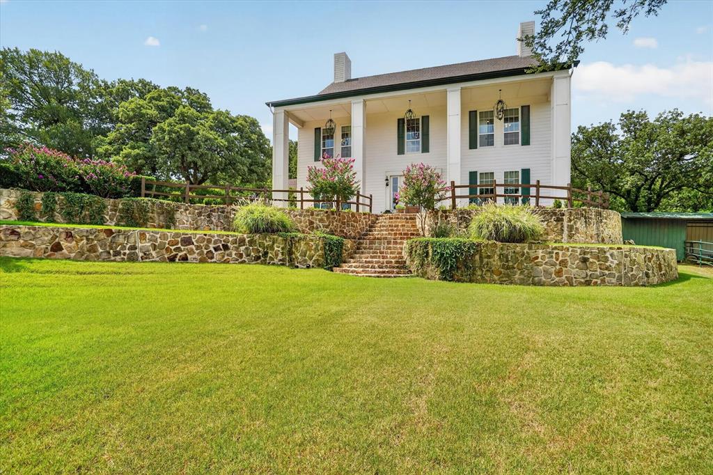 Resort-Style Dream Home perfect for Multi-Generational Living! Enchanting gated colonial antebellum-style estate tucked away 4.3-ac serene acres in Arlington. From the moment you pass through the electric gates, this secluded oasis makes you feel a world away, seamlessly blending country peace with city convenience. Built with meticulous detail, the 3-story, 6,062-sqft, 8-BE–all with ensuite baths-features 10-foot ceilings, solid wood doors and wood-look tile throughout. This exquisite estate is perfect for multi-generational living or even as a future upscale Bed-and-Breakfast. A 1st-floor primary suite with a handicap-accessible shower, a stunning cast-stone gas fireplace and a newly renovated commercial kitchen. Chef’s dream kitchen features include a 6-burner, high-end cooktop, double ovens, dual islands, two dishwashers, a 64-in fridge freezer combo and a newly built butler's pantry, coffee bar. Upstairs, a spacious game room with its own kitchenette and bar perfect for guests and fun family nights. The Owner's Suite on the 3rd Floor is an impressive 1,216 sqft accessible via a private staircase or elevator. Enjoy a primary bedroom and living combo, wet bar, office nook, heated bathroom floors and private laundry room, complementing the 1st-floor laundry closet. The separate carriage house offers a 1,500 sqft downstairs workshop, RV AND boat garage AND storage complete with epoxy floors. Upstairs, a fully remodeled 1,500 sqft, 2-bedroom, 2.5-bath guest suite features a full kitchen, living and dining area, with its own private entrance. The lush property backs to a quiet creek and boasts mature trees, turf lawns, three fenced paddocks and two loafing sheds. Upgrades include a generator, an 8-person tornado shelter, a new roof built in 2026, and foam insulation. No HOA. With its endless space and resort layout, this estate is a dream come true for large-scale entertaining or premier bed and breakfast. Energy efficient foam insulation. 4 combined lots: 4.26 ac