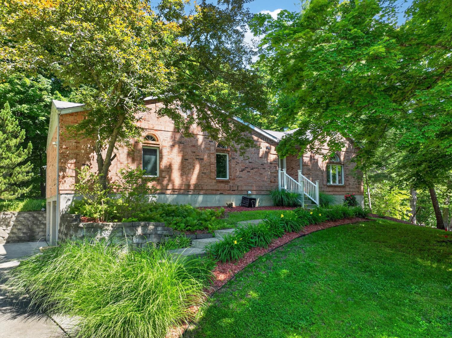 MOTIVATED SELLER - DOUBLE LOT! This all brick transitional ranch offers an open floorplan in a private wooded setting! Set on a knoll away from the street, the home features a wonderful almost level back yard surrounded by woods, and a huge deck off the Great Room to enjoy the views of nature. Spacious vaulted Great Room/Dining Room combo with corner WBFP is open to a contemporary-style kitchen, complete with pantry, convenient coffee bar & pass-thru to the Dining Room. Space for a kitchen table here as well. The vaulted Master sits in the back corner overlooking the woods, with 2 walk-in closets & a divided bath. Two other bedrooms & another full bath on the main level, plus a finished lower level with large Family Room, multi-purpose office/exercise room, half bath & laundry/utility. The built-in garage, complete w/ deep sink & workbench is a true man-cave! Newer roof, HVAC & water Softener. Repainted throughout! 2,288 finished sf. 1 yr Choice Plus Home Warranty. GREAT CONDITION!