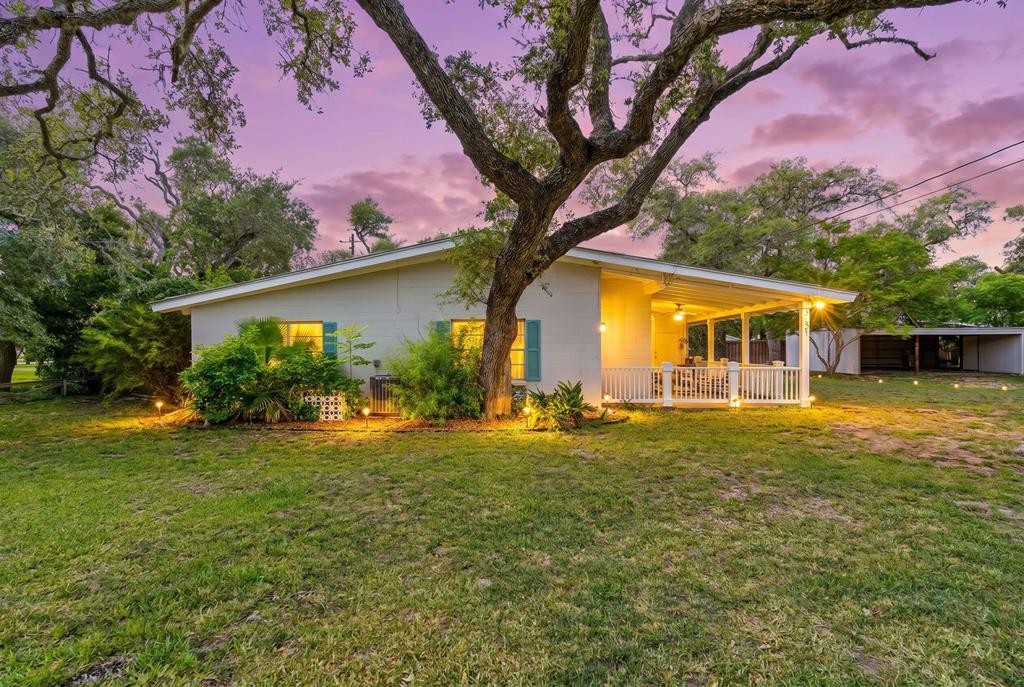 One home on two lots, being sold by the original family, Connally's Cottage has been a beloved home and the backdrop for decades of cherished memories. The three-bedroom home, thoughtfully designed for comfort and relaxation, features a screened-in patio, and an additional outdoor patio for entertaining or simply soaking in the serene surroundings. The large private yard offers both space and privacy, ideal for gatherings, gardening, or simply enjoying the coastal breeze. In total there are two lots being sold in this package. The second lot has the detached carport. From the screened-in patio, residents and guests are treated to a picturesque view of Aransas Bay, making it the perfect spot to watch the early morning sun rise over the water or to witness the full moon casting its glow across the bay. The home's interior is a delightful blend of vintage, antique, and modern furnishings, offering a warm and inviting atmosphere that reflects its storied past. Beyond the three bedrooms, there is an additional sleep area adjacent to the fireplace featuring two twin beds, making it easy to accommodate family and guests. For those with a love of boating or outdoor adventure, the long driveway provides ample space for storing a boat, jet skis, or other recreational vehicles. The location of this home is up high and just a stones throw from Fulton Beach Road, where you can stroll or fish. This home is a retro gem, full of character and original features, exuding charm at every turn. Whether you are looking for a peaceful retreat, a space to create lifelong memories, or a coastal getaway with direct access to the beauty of Aransas Bay, Connally's Cottage provides it all.