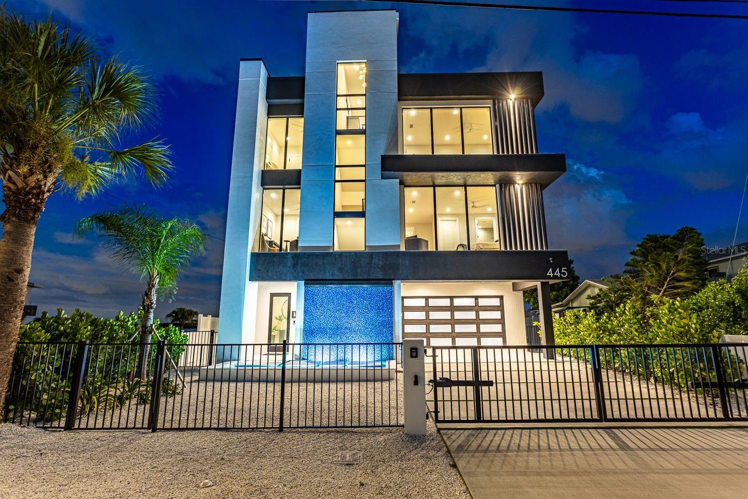 This architectural marvel, designed and developed by Tulia Homes, is an artistically thoughtful residence that is the epitome of luxury waterfront Florida living. Location is everything with this home, which is nestled on a peninsula overlooking Boca Ciega Bay, with clear sightlines to Little Bird Key and Eleanor Island. You can enjoy ocean breezes with sunsets or sunrises, whether you experience them inside or out. Owning this home is more than owning a house — it's a lifestyle, and it does not disappoint. Your private dock allows convenience when you embark on boating excursions to the Gulf, with quick and easy access through John's Pass. This 5,785 sq. ft. residence boasts an open-floor living space for ultimate entertaining, five bedrooms, four en suites, one and a half guest baths, a gym/yoga meditation room, pool/spa, 360-degree view rooftop, and an eight-car parking garage. Enjoy picturesque views from every corner of this home. Floor-to-ceiling windows overlooking the ocean to the east allow for perfect sunrises as dolphins swim by while you sip your morning coffee from one of the expansive terraces or relax by the saltwater pool. High above sea level is the main living space, thoughtfully designed for coastal living and entertaining. A chef's kitchen, butler's pantry, two living areas, wet bar, temperature-controlled wine room, and a dining room all overlook the shimmering sea. All of this can be enjoyed with the entire wall of windows automatically opening to the fresh ocean breeze. This level also has two guest bedrooms (or office) with en suites, walk-in closets, and a powder room. On the second floor, you will find two guest bedrooms, two bathrooms, a fitness room, laundry area, an informal living room, and a spacious and serene primary suite with its exquisite spa-like bathroom equipped with a breakfast bar, double shower, soaking tub, and formal dressing room. Next, take the all-floor-access elevator up to the third floor and be greeted by a wet bar, which leads you to an incredible 360-degree view rooftop — perfect for spectacularly memorable sunsets or improving your putting skills, all while overlooking the ocean.All of this is located just steps away from the John's Pass Boardwalk, John's Pass Park & Beach, and everything Gulf Boulevard has to offer. Tulia Homes doesn't just build homes — they build sanctuaries for joy, pride, and cherished memories with family and friends for generations to come!Contact us today to schedule a private tour of this breathtaking and visually stunning property, sitting at the access point of the Gulf and the apex of Florida coastal living
