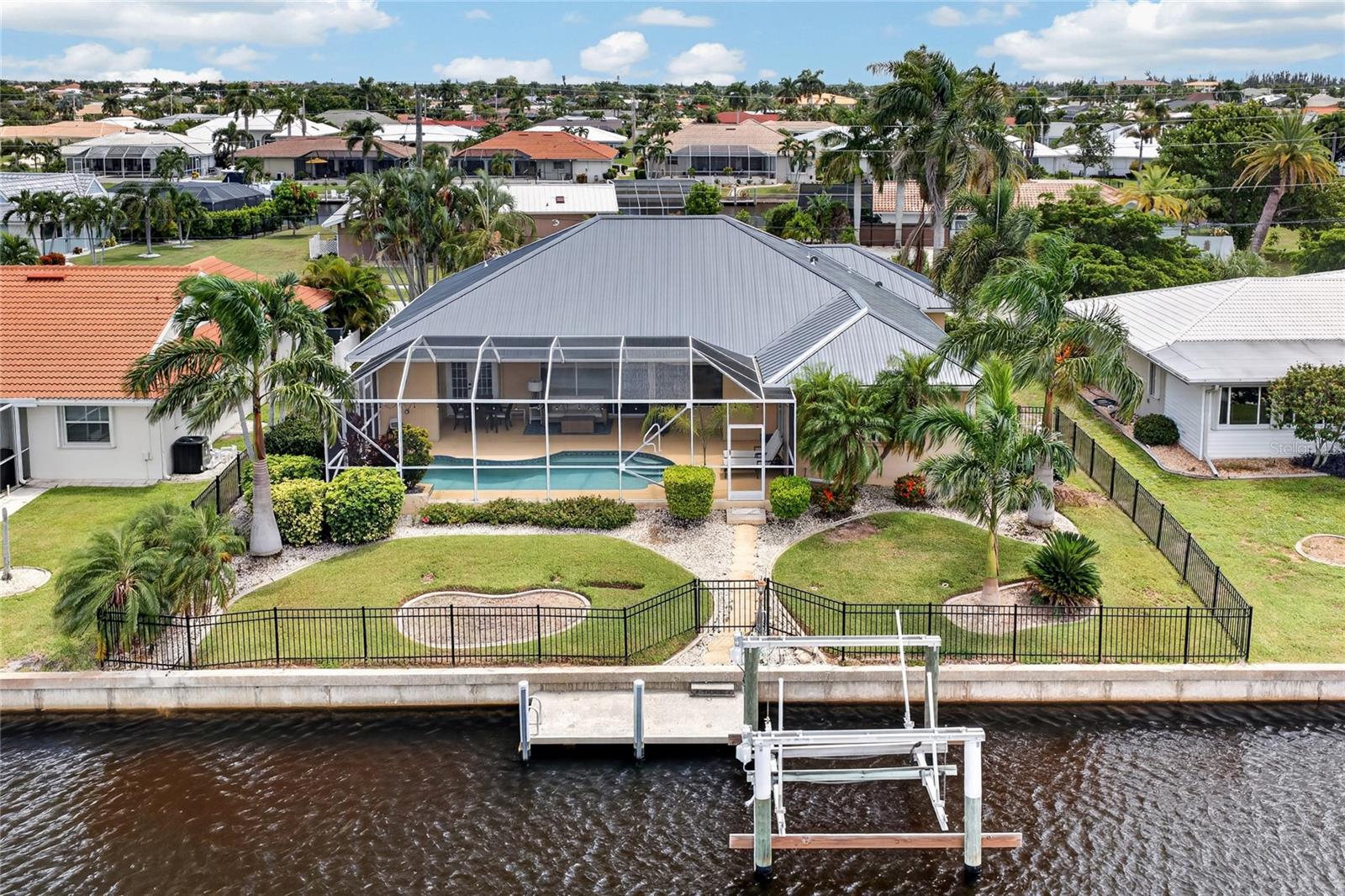 WATERFRONT LIVING, BEAUTIFULLY REMODELED, 3-CAR GARAGE, POOL HOME featuring WI-FI-OPERATED ROLL-DOWN HURRICANE SHUTTERS—and a hidden surprise you won't see coming. All in the HEART OF PUNTA GORDA ISLES, this exceptional 3-bedroom + BONUS ROOM, 2.5-bath home pairs polished interiors with the Southwest Florida boating lifestyle. Complete with a PRIVATE DOCK, 10,000-LB BOAT LIFT, and a SHORT BOAT RIDE TO OPEN WATER.From the moment you step inside, it's clear this home has been thoughtfully updated and exceptionally maintained. WOOD-GRAIN TILE FLOORING flows throughout most of the home, creating a warm, cohesive look while expansive living spaces and POCKET SLIDERS open the interior directly to the lanai and pool. It's the kind of layout made for Florida—bright, open, and designed to bring the outdoors in.At the heart of the home, the LARGE KITCHEN offers plenty of room to cook, gather, and entertain, featuring GRANITE COUNTERTOPS, STAINLESS STEEL APPLIANCES, generous cabinetry, and abundant workspace.But one of this home's BEST FEATURES is hiding in plain sight. The BONUS ROOM has been transformed into an unexpected HOME BAR—tucked away so seamlessly that you'd never know it was there. Open it up when it's time to entertain, then close it away when the night is over. It's unique, fun, and an unforgettable detail that sets this home apart.The PRIMARY SUITE is spacious and inviting, with its own POCKET SLIDERS providing direct access to the lanai and pool. The en-suite bathroom feels like a private retreat with DUAL SINK VANITIES, LED MIRRORS, a SOAKING TUB, and a generously sized walk-in shower. Two additional bedrooms provide comfortable space for family or guests, including one equipped with a convenient MURPHY BED.Outside is where the Punta Gorda lifestyle really takes over. The HEATED SALTWATER POOL is surrounded by a spacious screened lanai, complete with an OUTDOOR SHOWER and a HALF BATH conveniently located just off the pool. A WI-FI-OPERATED ROLL-DOWN LANAI SCREEN adds another level of convenience, allowing you to easily adjust the outdoor space for relaxing, entertaining, and everyday Florida living.BOATERS, THIS ONE DELIVERS. Situated on a SALTWATER CANAL, the property features a 7' X 15' DOCK with WATER AND ELECTRIC plus a 10,000-LB BOAT LIFT. From your own backyard, you're just a SHORT BOAT RIDE FROM OPEN WATER and everything that makes living in Punta Gorda Isles so special.A METAL ROOF REPLACED IN 2022 adds another major upgrade, while WI-FI-OPERATED ROLL-DOWN HURRICANE SHUTTERS offer convenient storm preparation at the touch of a button. The THREE-CAR GARAGE provides excellent space for vehicles, storage, and all the extras that come with waterfront living.BEAUTIFULLY REMODELED. METICULOUSLY MAINTAINED. BUILT FOR BOATING, ENTERTAINING, AND FLORIDA LIVING. 959 BAL HARBOR BOULEVARD isn't simply a home in PGI—it's the lifestyle people move here to find.