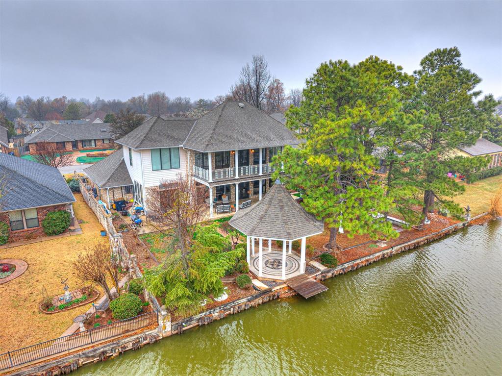 Rare lakefront opportunity on 1.09 acres in Lakeridge Run, offering breathtaking water views and over 5,000 square feet of living space thoughtfully designed to take full advantage of its setting. Expansive windows frame panoramic lake views and fill the home with natural light. A striking double-sided stone fireplace anchors the main living area and adjoining library, while crystal chandeliers add a warm, refined glow throughout the home. The main-level primary suite features a whirlpool tub and dual walk-in closets, with two additional bedrooms also on the main level. Upstairs, a custom iron staircase leads to a private suite and flexible living space ideal for guests or recreation. Outdoor living includes a balcony, covered patio, gazebo, fishing dock, and firepit with built-in seating overlooking the lake. The 1.09-acre property extends across the lake to include the opposite shoreline, enhancing privacy and the natural setting. Ideal for both peaceful lakeside living and effortless entertaining.