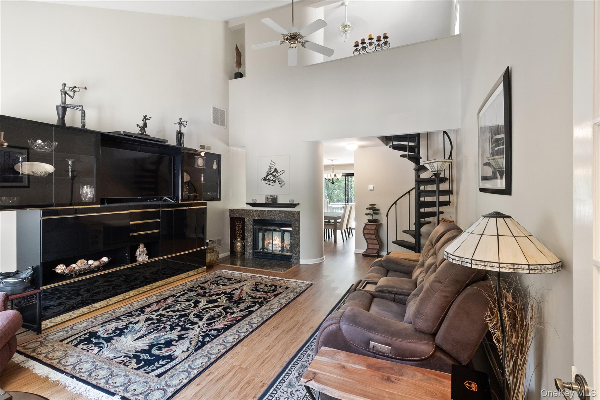 This value-packed, move-in-ready upper-level condominium is located at the end of a cul-de-sac in Oakridge Condominiums, Vista, NY. Offering approximately 1,312 sq ft, this residence includes a vaulted loft and a bonus room. This home provides a flexible living space ideal for a home office, den, exercise room, hobby area, or additional storage. This south-facing home features a landscaped garden area with two shade trees. Enter through the French door into the living room with engineered wood flooring, cathedral ceiling, and a wood-burning fireplace. The dining area and kitchen feature sliding glass door access to a deck with wooded views. The kitchen features tile flooring, beveled countertops, maple cabinetry, and stainless-steel appliances. Off the dining area is a hallway with a full-size washer/dryer closet, a linen closet, and a ceramic tiled bathroom. The primary bedroom features a cathedral ceiling, double-tier closet, and mirrored wardrobe/storage wall unit. An additional main-level room offers flexible use for office, den, fitness, or hobby space. Recent updates include a newly installed HVAC system (2026 heat pump and air handler) and a new 40-gallon hot water heater (2025). Interior walls and ceilings were professionally painted in 2023. Additional improvements include upgraded window treatments, interior doors, Andersen front windows, and ceiling fans in the living room, primary bedroom, and loft. Located in the desirable Oakridge Condominiums community in Vista, New York, with convenient access to shopping, commuter routes, and nearby amenities. Community amenities include three pools, two tennis courts, and a basketball area.