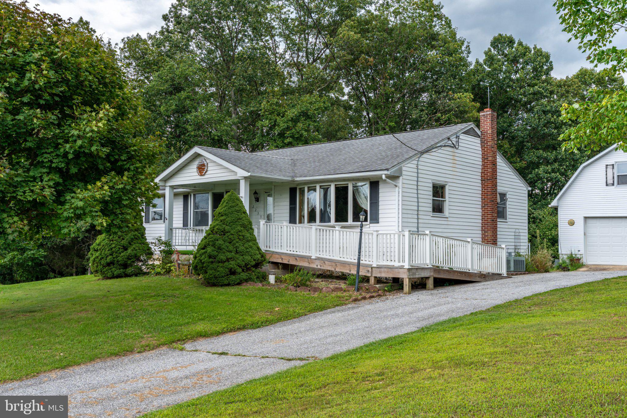 Delightful ranch-style home located in Manchester just below the Mason Dixon Line.  With 1.52 acres and a fantastic detached 2 story garage/workshop, this property is ideal for the hobbyist or collector while allowing room to grow on the large private lot.   Step inside to find a warm and inviting interior featuring beautiful hardwood floors,  comfortably sized kitchen, large bathroom with vaulted ceilings, and a versatile studio space that could also be used as a home office or converted to an additional bedroom.   An attic provides additional storage and the home also includes a main level laundry room and half bath.  The combination basement with a walkout entrance offers a 2nd hobby room or workshop, and additional living space.  Outside, the expansive lot backs to lush trees, creating a private tranquil backdrop for outdoor activities.