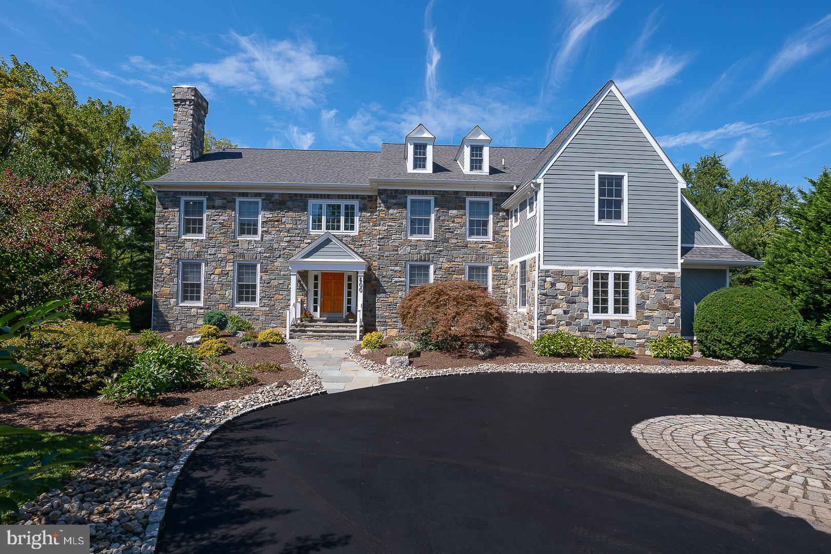 Stately Stone Colonial? Circular driveway? Open floor plan? All of this and more in this American Dream House, masterfully designed, beautifully and privately situated, and only 20 years old, in prestigious north side Villanova, Lower Merion Township. This exceptional 5-bedroom, 5.2-bath residence sits on a 0.72-acre flat lot in an exclusive enclave of only 9 homes. The modern floor plan includes a home office, five living areas, a chef's kitchen, a finished lower level, fantastic storage, and abundant natural light throughout. The front door opens to a sensational grand foyer and custom-turned staircase, with gleaming 3/4" hardwood floors and a front-to-back view of the home.Surrounding the foyer are elegant formal Living and Dining rooms. To the right, the formal Dining Room showcases a tray ceiling, wainscoting, and direct access to the Butler Pantry. To the left, the formal Living Room impresses with nearly floor-to-ceiling windows, double crown molding, and a marble-faced gas fireplace. French doors reveal a spacious Office/Library with floor-to-ceiling bookcases and lush green views, offering both serenity and functionality for today’s work-from-home lifestyle. The Butler Pantry, complete with a wet bar and wine refrigerator, leads into the expansive gourmet Kitchen with a spacious center island, granite countertops, Sub-Zero refrigerator, large 48-inch Viking stainless gas cook top, Dacor 30-inch double wall ovens, Bosch dishwasher, and a walk-in pantry. A double-height Palladian window and skylights bring the outdoors in. A Sunny Breakfast Room with sliders leads to a dramatic 4-season Solarium with a heated floor, perfect for indoor-outdoor dining and entertaining.  With its wrap-around glass and views of the grounds, you may wish to spend your entire day in this bright and delightful space. An adjacent covered deck adds even more indoor-outdoor square footage to the footprint. The Kitchen is open to an expansive Family Room, the center of the home, featuring a travertine gas fireplace, coffered ceiling, and nearly floor-to-ceiling windows allowing views of the rear grounds. All this connectivity between the main level rooms creates the perfect environment for either casual and comfortable relaxation with family or lavish hosting with many friends.  Two Powder Rooms, a large Laundry Room, and a Mudroom area leading to a side-entry three-car garage complete the main level. On the second level, the primary bedroom suite features a large sitting room, dressing and vanity area, his and hers walk-in-closets, and a deluxe marble-clad spa bath with a marble shower, Jacuzzi tub, dual vanity and cabinetry, and soothing neutral colors for a serene retreat. The second Bedroom is another large suite, with a full bath, a good-sized walk-in closet, and a Sitting Room/Office/Library with built-in bookshelves. The third and fourth Bedrooms, amply sized with excellent closets, share a Jack & Jill bath. The fifth bedroom includes a full bath and a nice walk-in closet. All the vanities have Corian counters with integral bowls.The third floor is perfect for extra storage or the possibility of more living space. By the Master Suite, there is a back staircase leading to the Kitchen/Mudroom area for easy exit. A gigantic finished lower level provides additional living space, a dedicated exercise area, three storage rooms, a full bath, and a blank slate on which to build a Playroom, Craft Room, Home Theater, and/or an additional bedroom. This 20-year-old beauty has had all stucco replaced with two stone chimneys and Hardie board. Beyond the property itself, the location elevates the experience. Walk to Black Rock Middle School, enjoy easy access to award-winning public and private schools, and take advantage of nearby shopping, fine dining, and beautiful parks. King of Prussia and Center City Philadelphia are just 20 minutes away, while Manhattan is an easy 90-minute trip—placing the best of the region at your doors