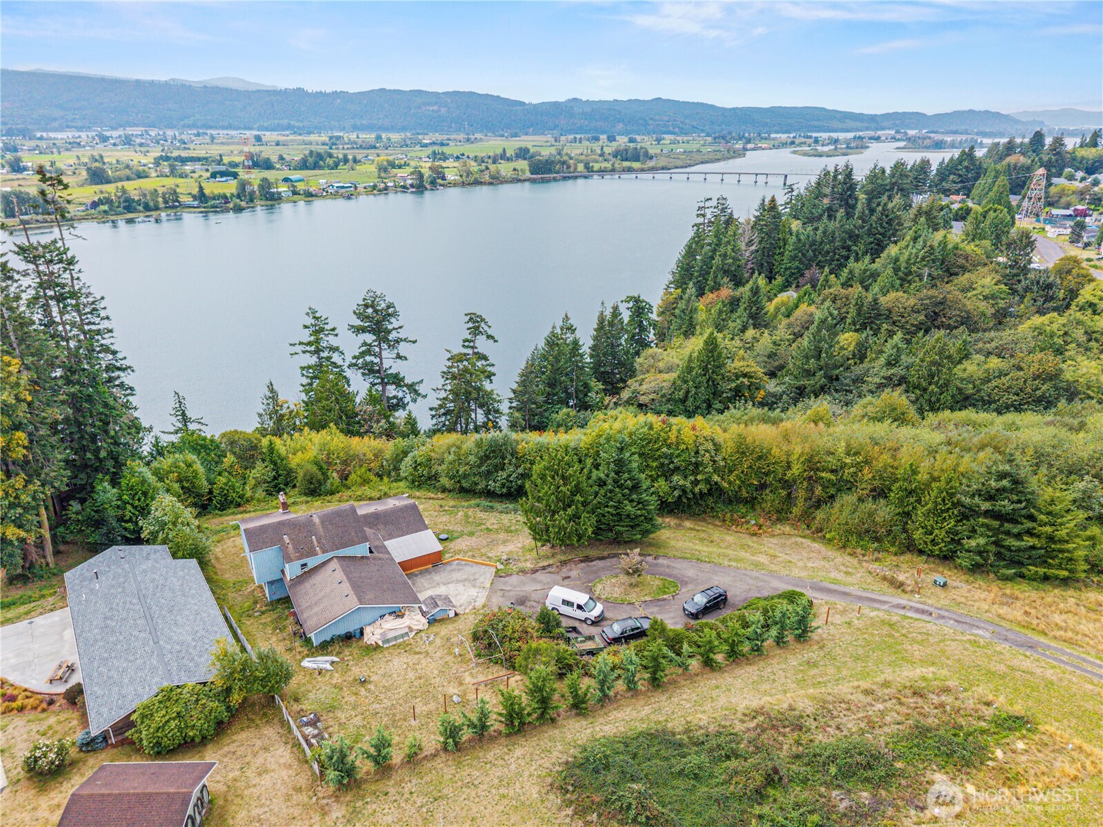 Captivating Columbia River views w/monumental space await at this solid, custom-built 4-bedroom home w/office perched on high-bank acre-plus lot in Cathlamet! Tucked away on a private lot, this mid-century gem showcases architectural character with striking cedar vaulted ceilings, rich wood accents, gorgeous viewing windows and sprawling, giant-sized rooms.  The grand footprint offers the perfect canvas to bring your design vision and a little TLC to create a world-class river view estate. Embrace the relaxes pace of Washington's historic coast with sweeping vistas of the shipping channel right from your window. Ideal for a spacious multi-generational home, a private getaway, or your next signature renovation project! Four bedrooms & office or nursery or five bedrooms, updated kitchen with breakfast nook, beautiful deck, large dining room with built-ins (and views!), giant great room, fireplace with insert (and views!!), generous primary with vaulted ceilings, private deck, walk through bath and laundry. Lower level features a second great room w/walkout to flagstone patio, large bedroom (or sewing/craft/den), mechanic/mud room/workshop w/walkout to patio w/built-in brick grill! Large, over-deep garage and simply stunning, private, covered front deck w/ambience you cannot believe!! Much has been to this home over the years but still provides for personalizing this beautiful space to your heart's desire. Square footage and opportunities at this price do not come along often...